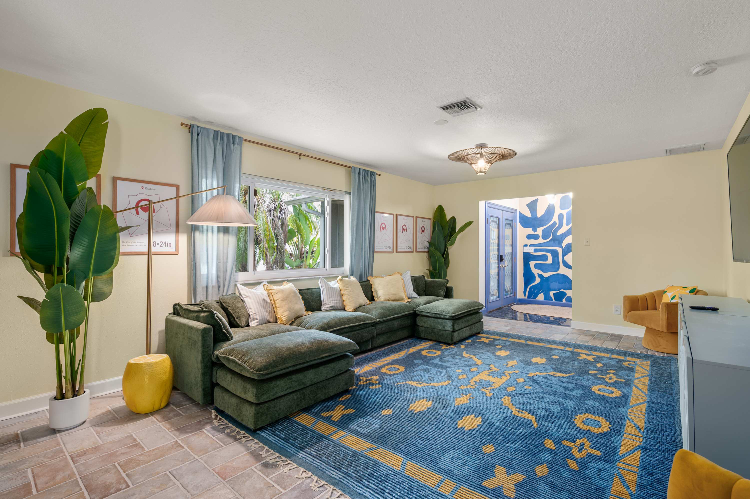 Bright living room w/ bold blue rug & stylish seating for the whole group.