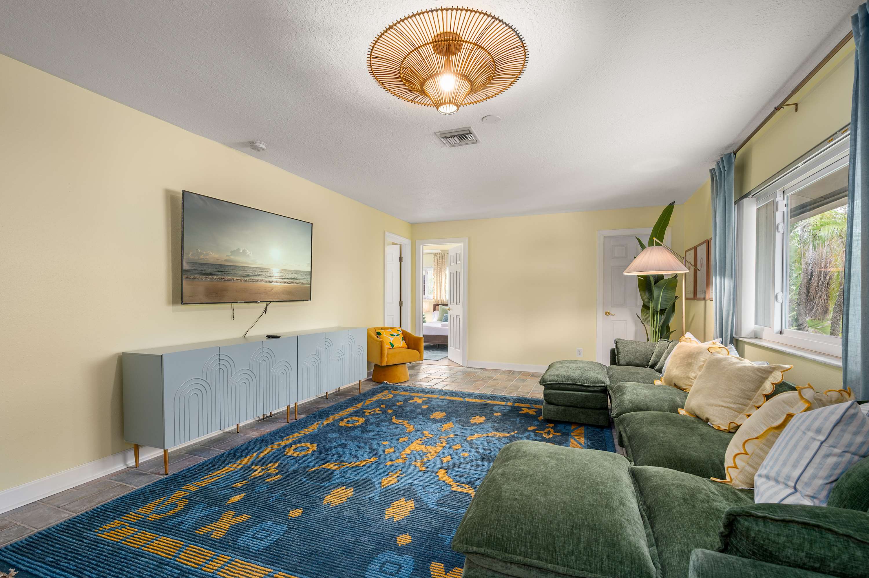 Inviting living room w/ plush sofas, blue rug & warm ceiling light.
