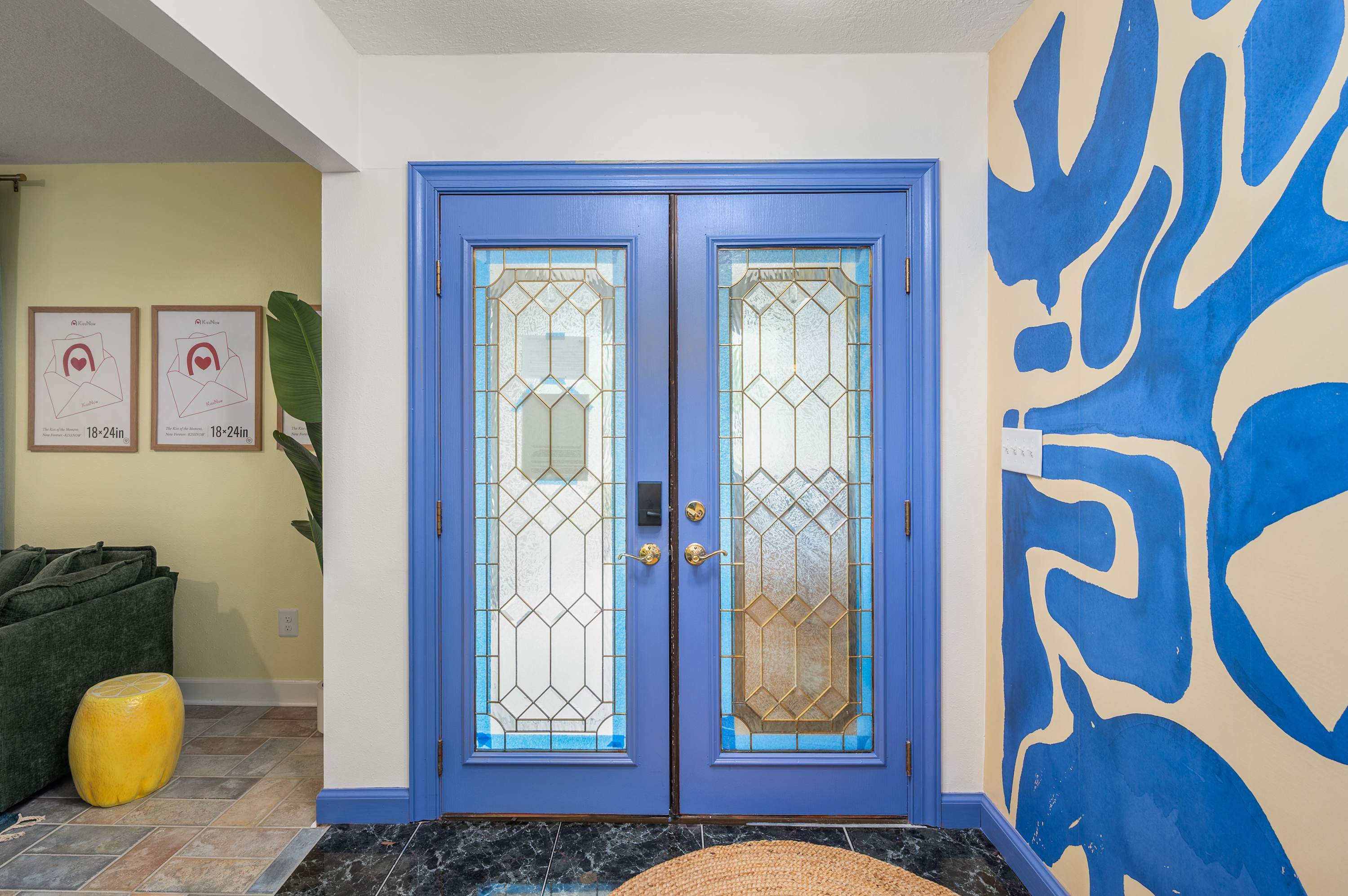 Welcoming entryway w/ bold blue door, stained glass & vibrant wall art.