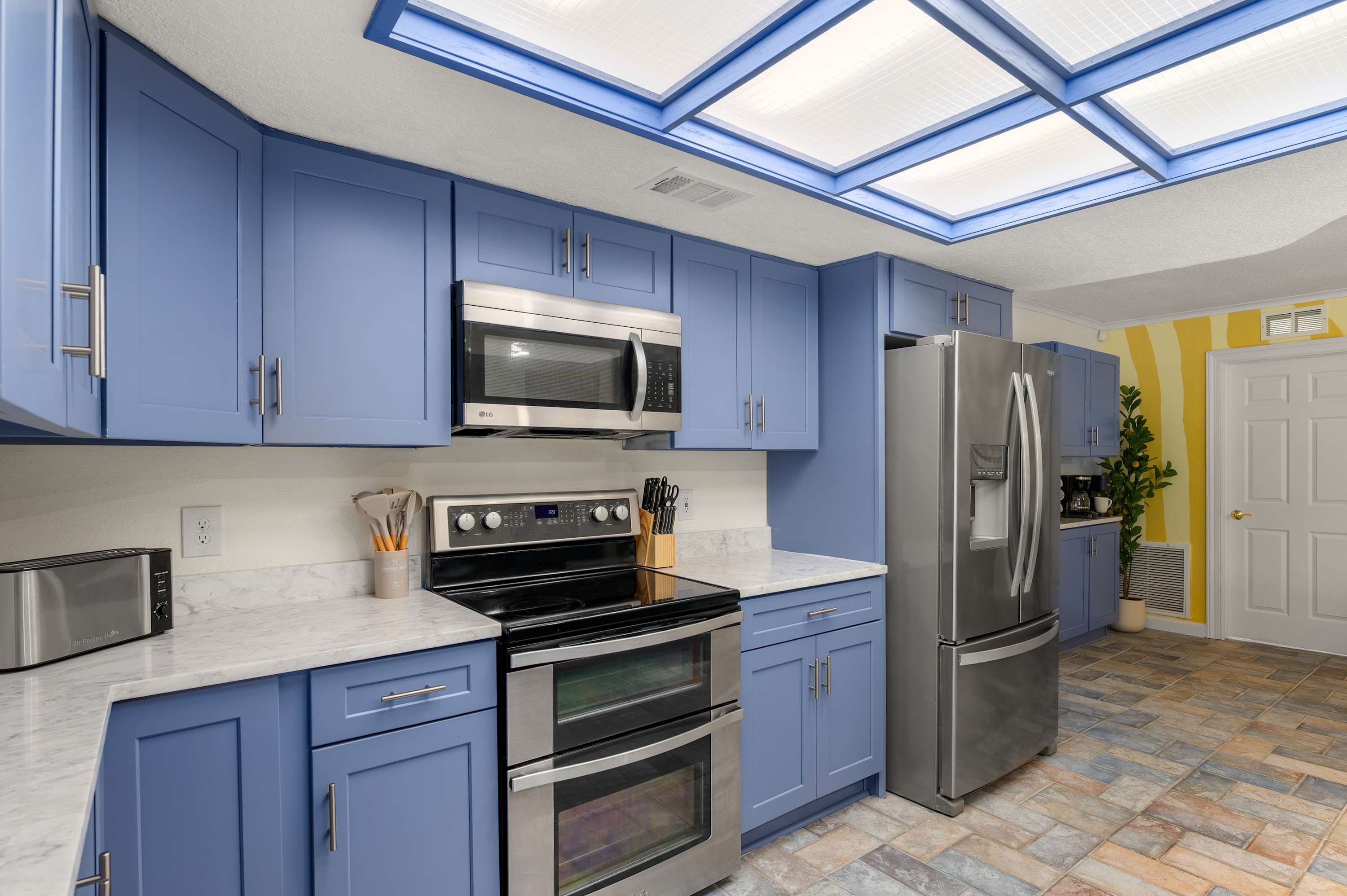 Full kitchen w/ blue cabinets, stainless steel appliances & ample counter space.