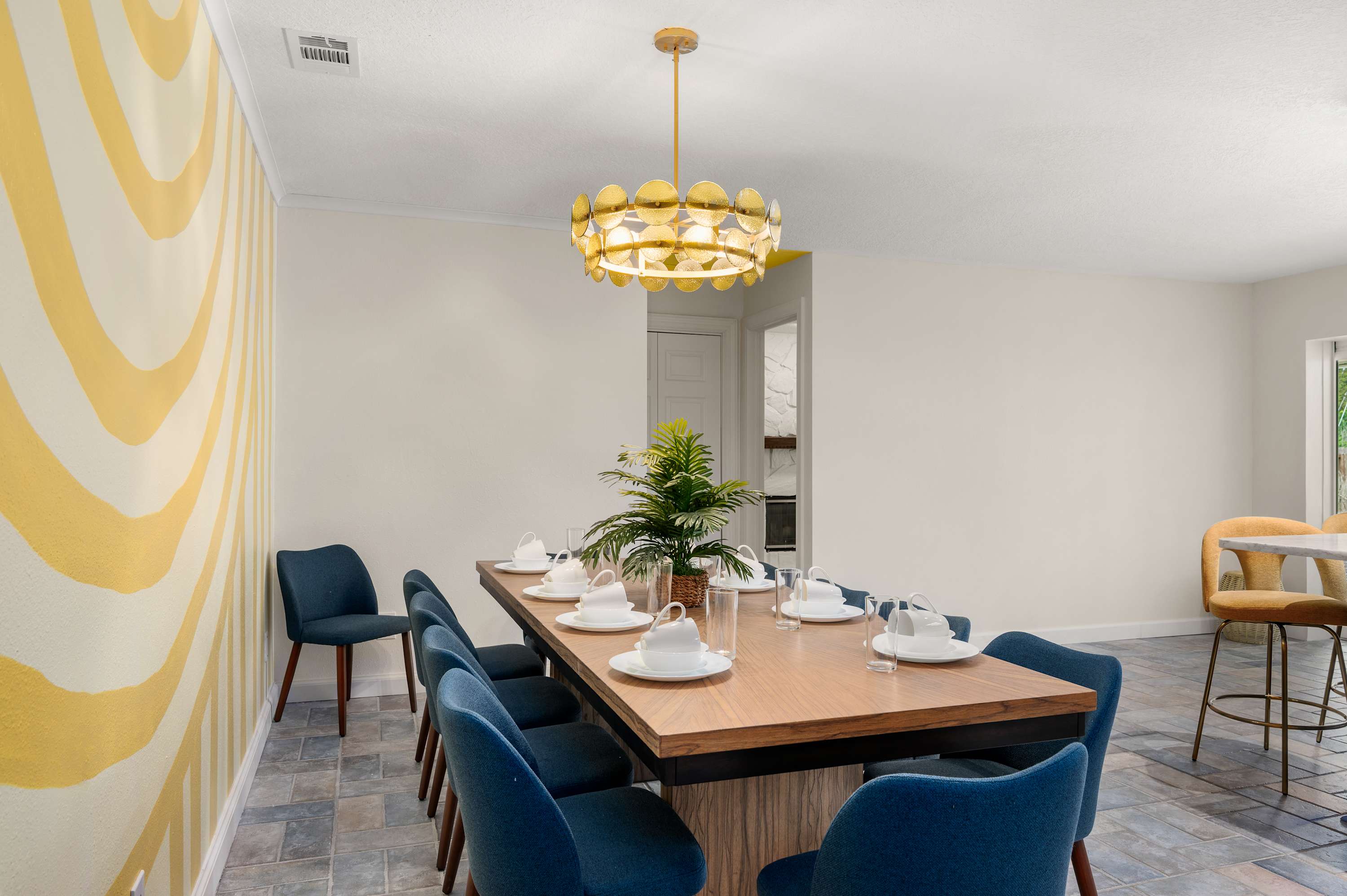 Sunburst dining room w/ a long wood table & seating for the whole group.