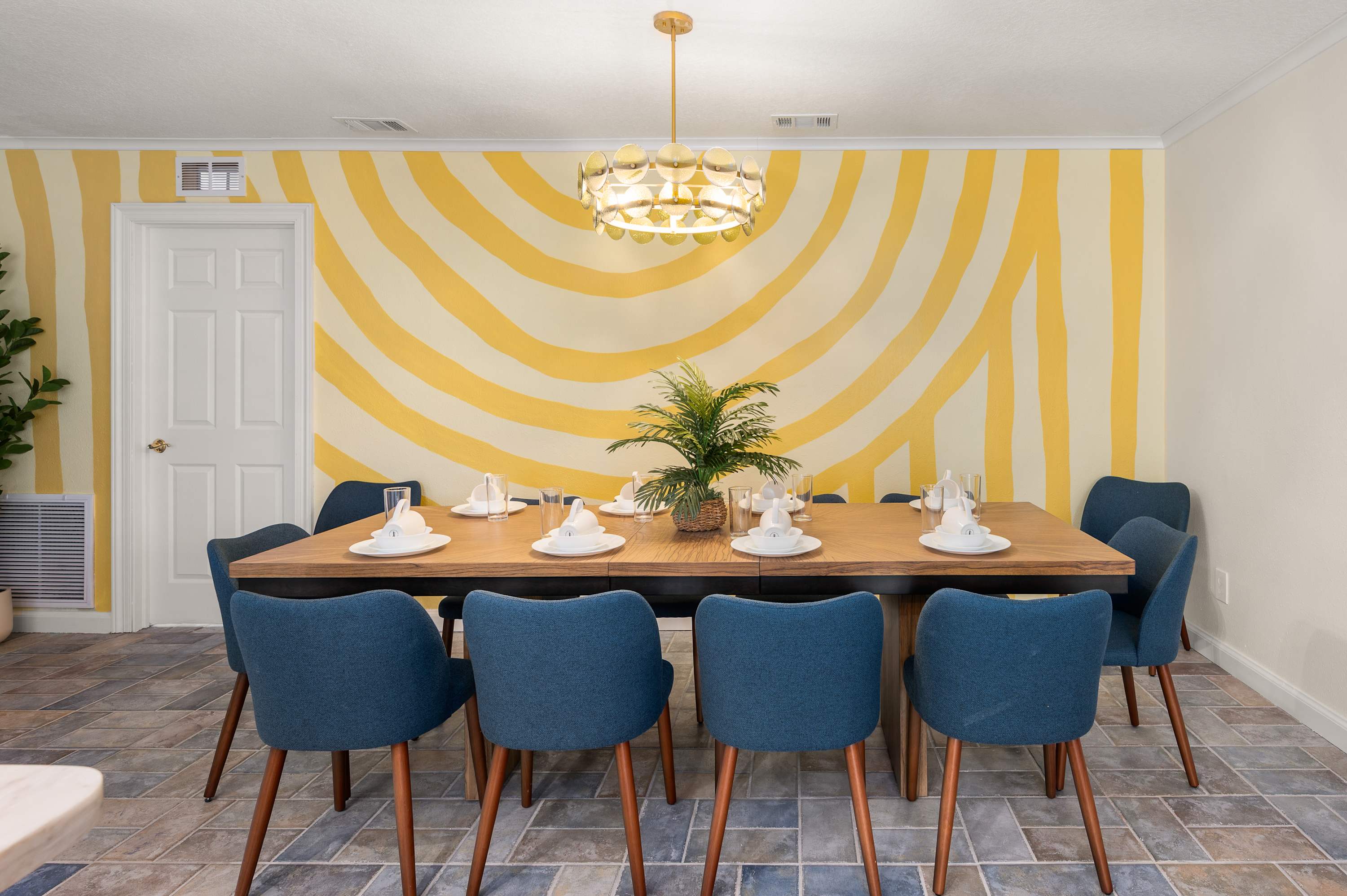 Sunlit dining area w/ a striking yellow sunburst wall & seating for 10