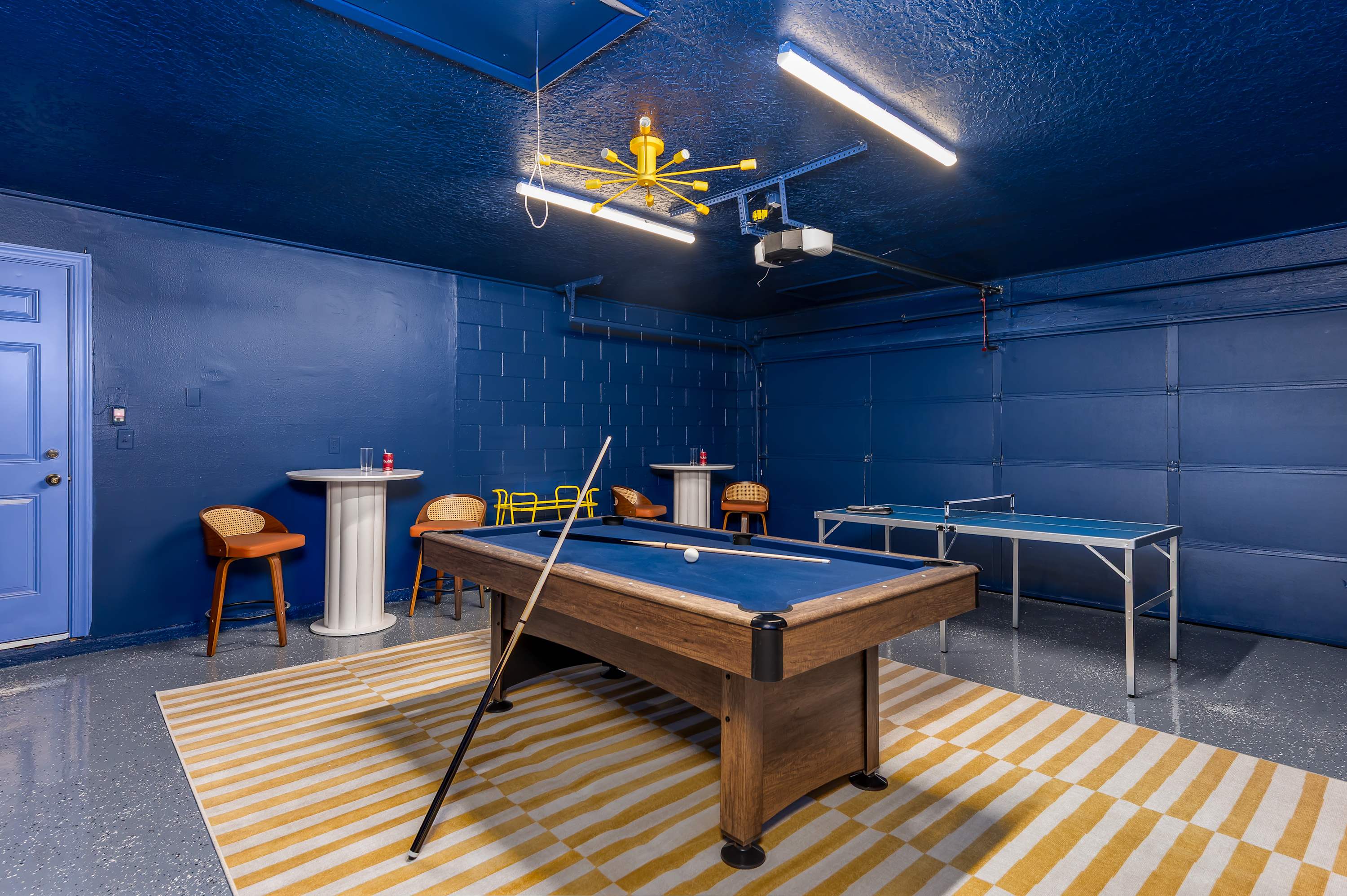 Fun game room w/ pool table & electric blue walls — perfect for a group night in.