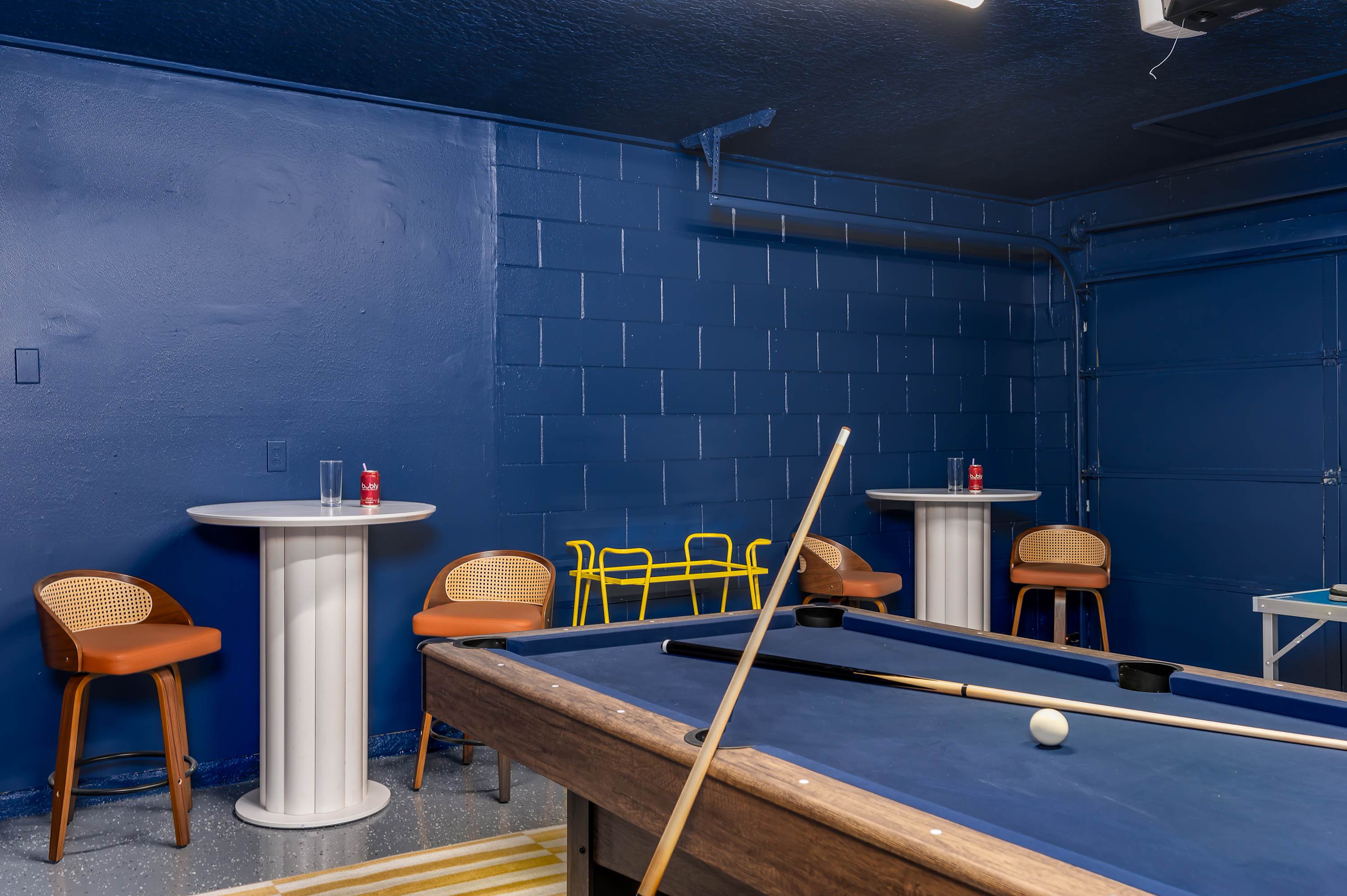 Game room corner w/ bar-height seating & shuffleboard — ready for a tournament.