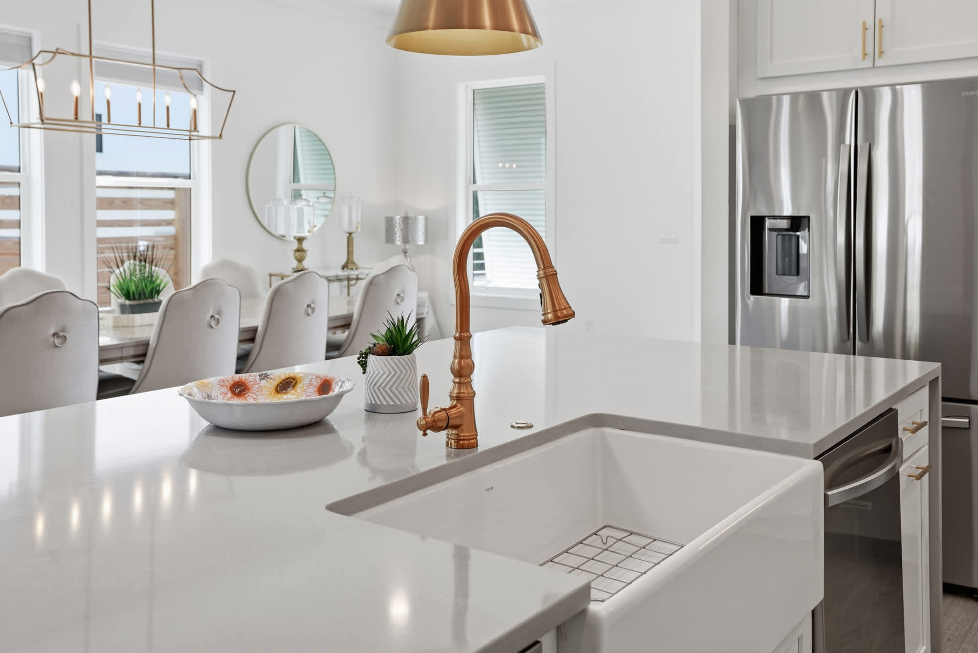 120 Dune Drive – Bright kitchen with white cabinetry, large island, stainless steel appliances, and dining area view.