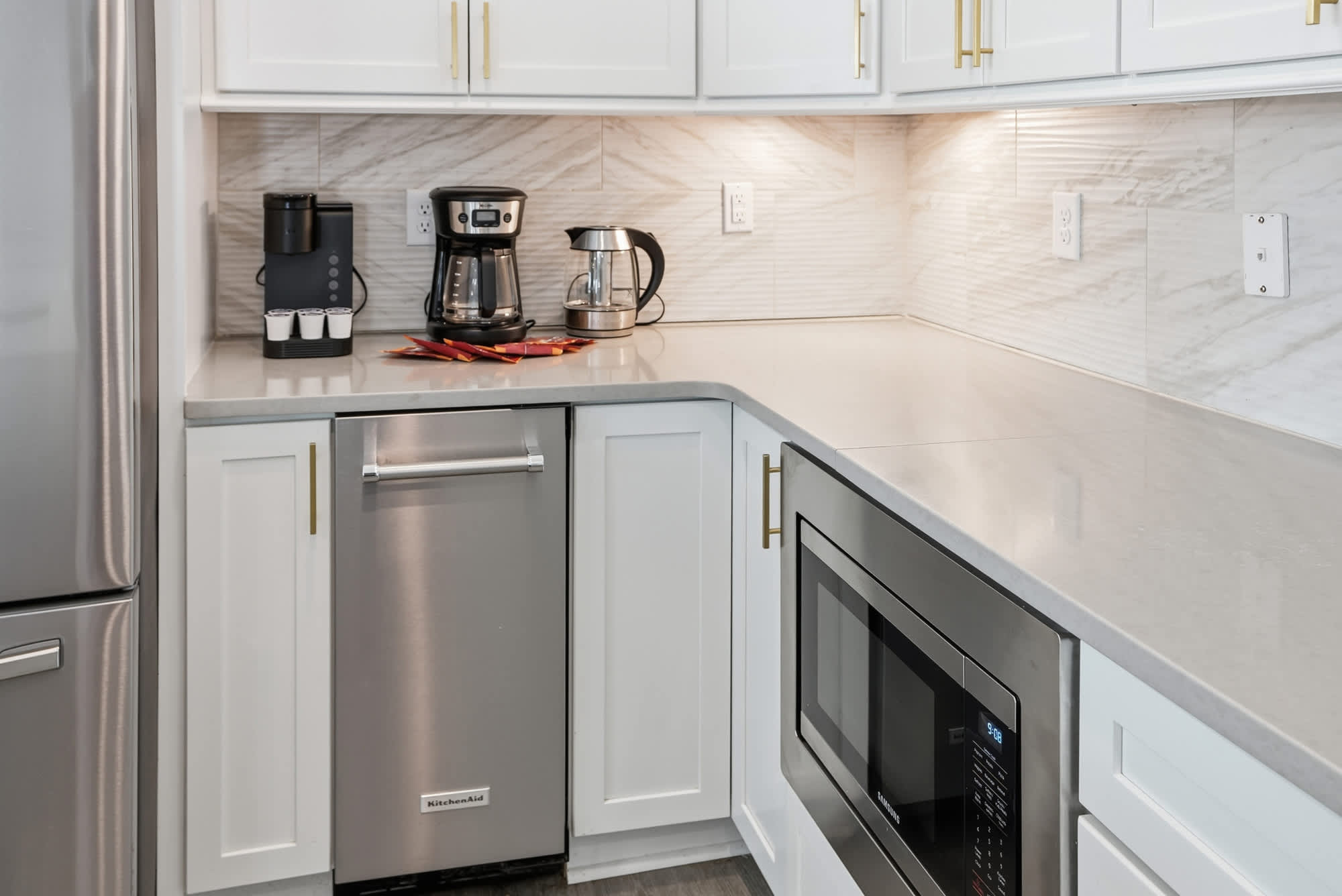 120 Dune Drive – Modern kitchen with stainless steel appliances, white cabinetry, and countertop.