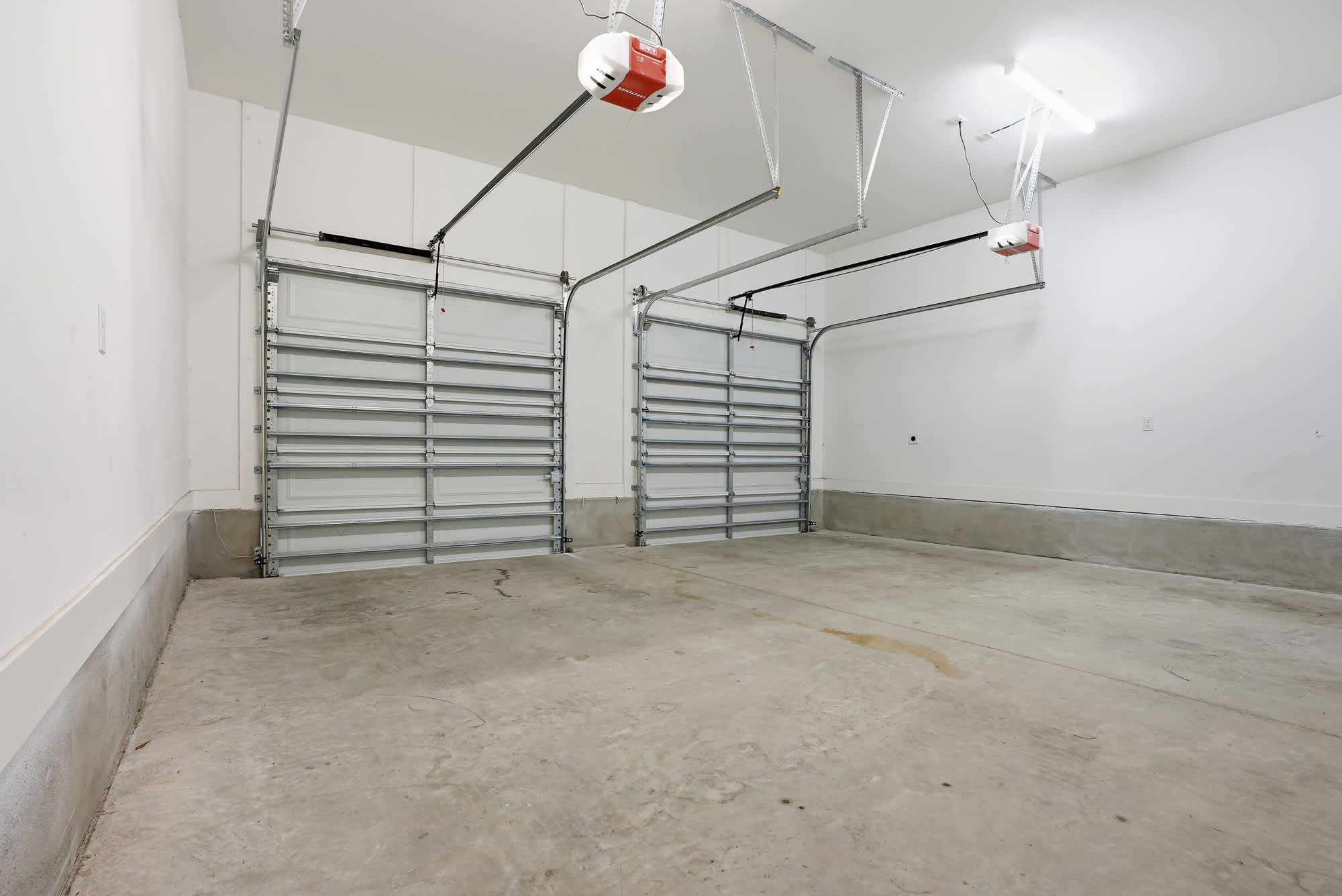 120 Dune Drive – Empty garage with two overhead doors and a concrete floor.
