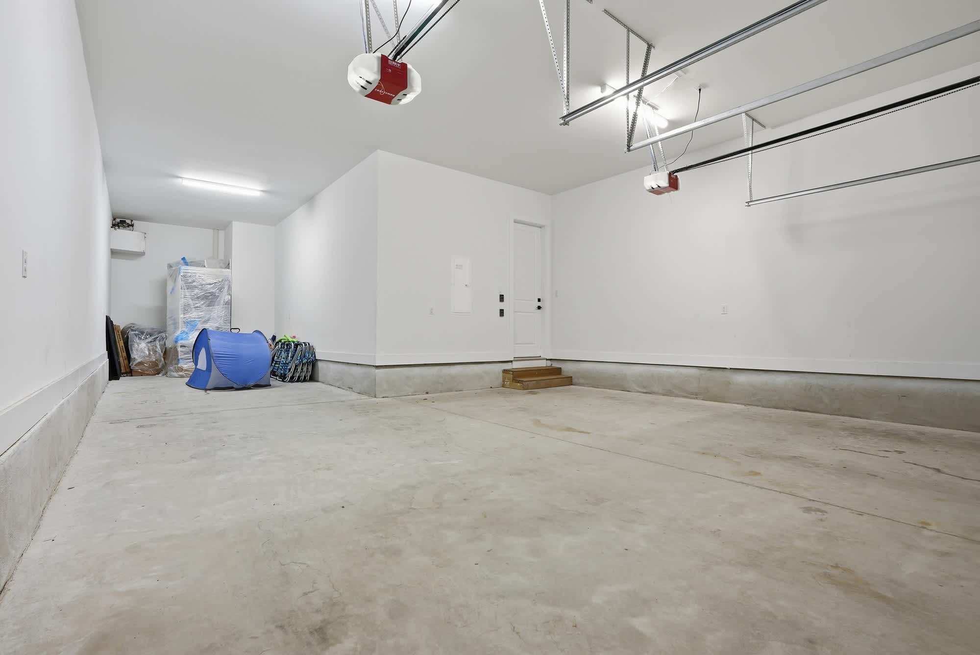 120 Dune Drive – Empty garage with concrete floor, white walls, and a door leading outside.