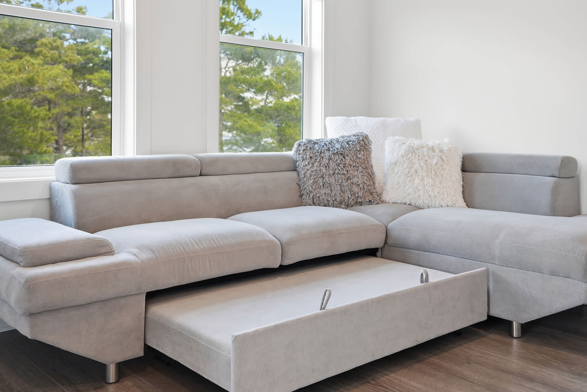 120 Dune Drive – Light-filled living room with a gray sectional sofa and decorative pillows.
