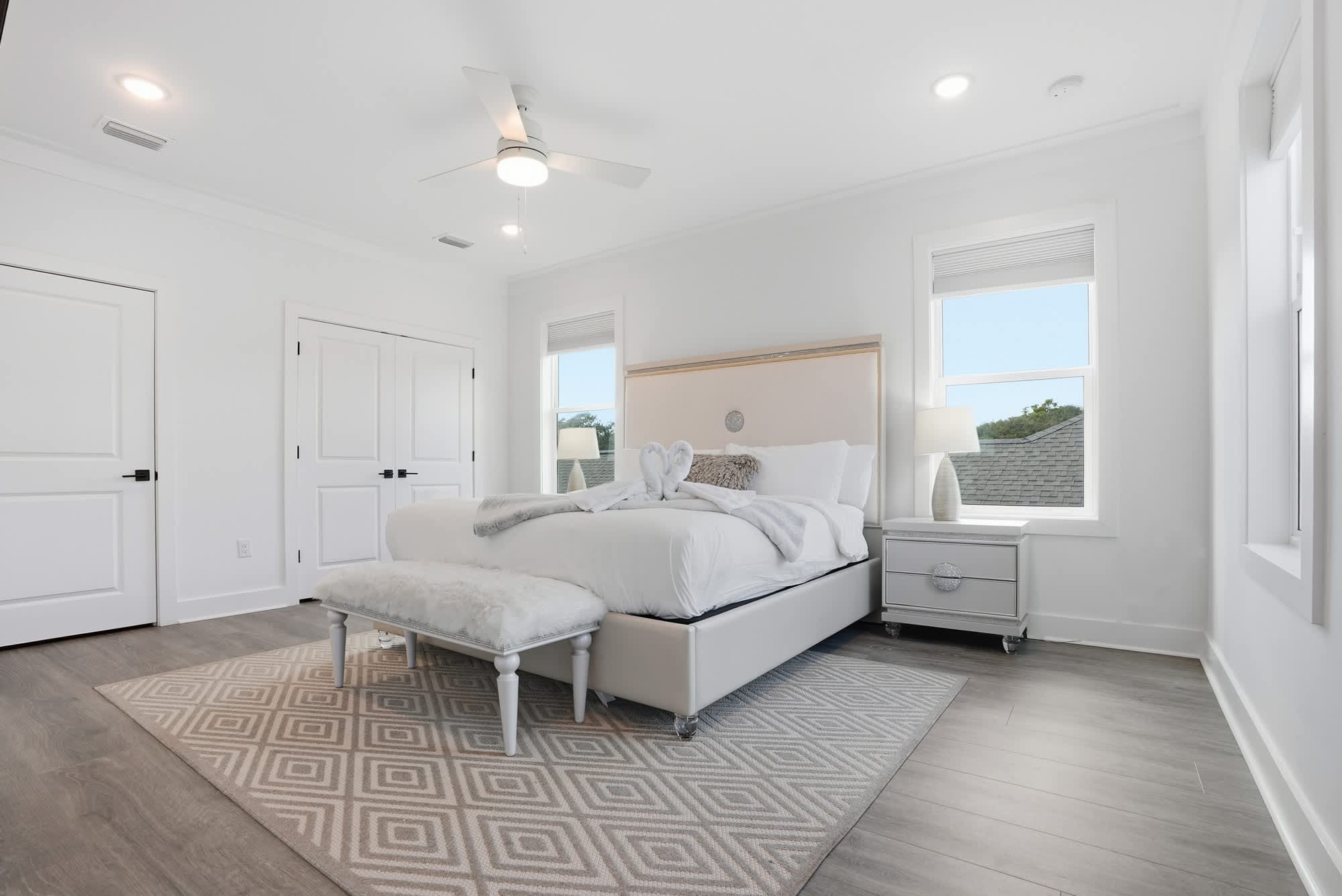 120 Dune Drive – Bright bedroom with a queen bed, nightstand, and windows offering natural light.