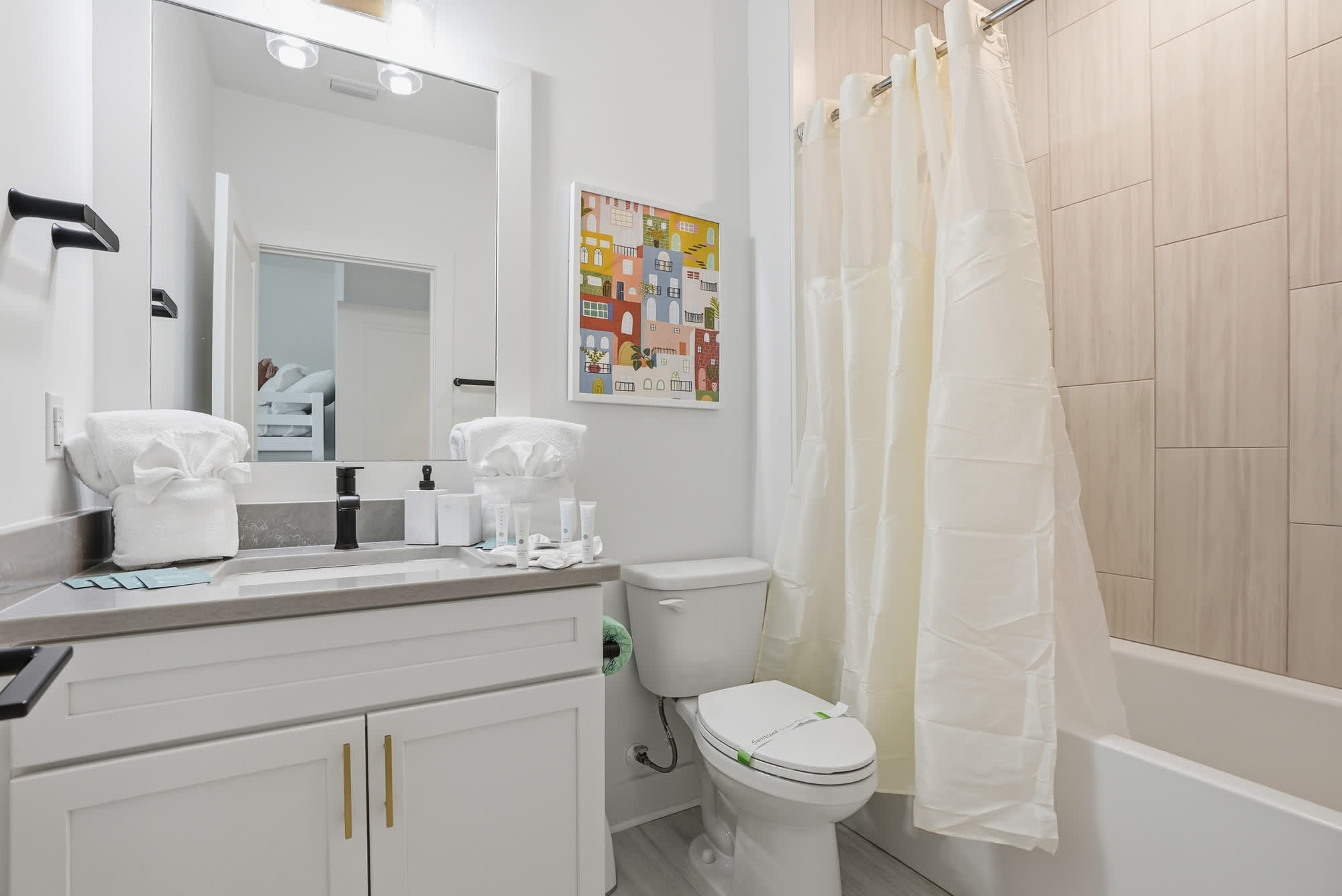120 Dune Drive – Modern bathroom with a sink, toilet, shower curtain, and decorative wall art.