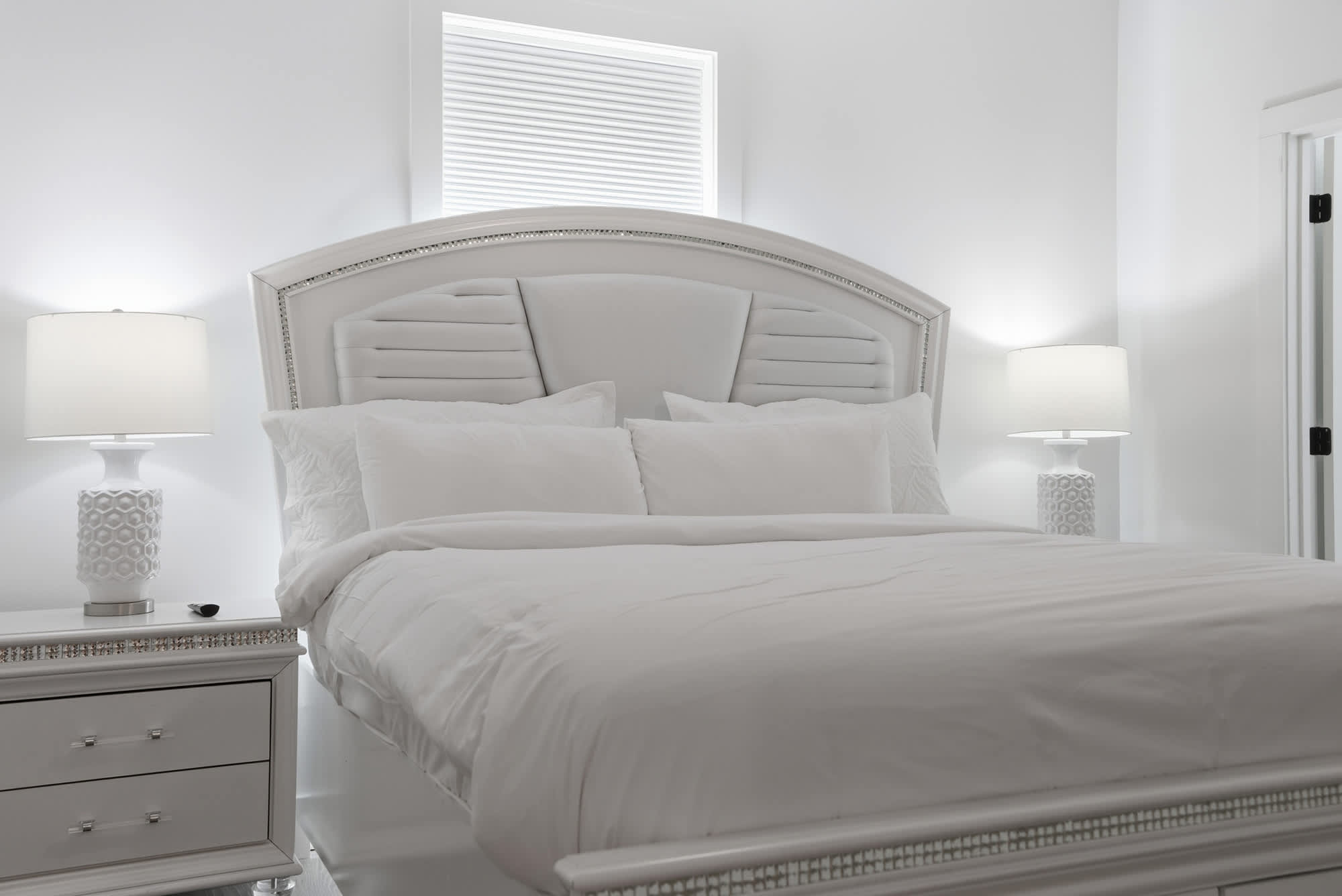 120 Dune Drive – Bright bedroom featuring a white bed, lamps, and a cozy ambiance with minimalist decor.