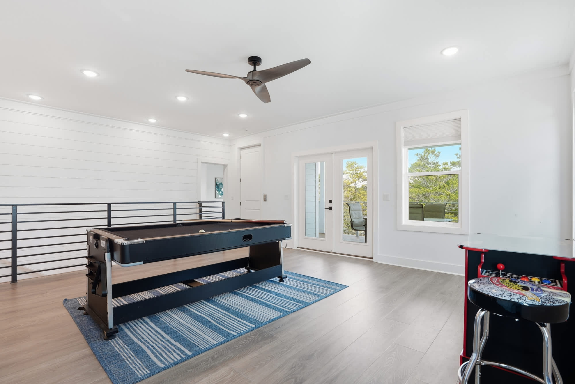120 Dune Drive – Game room with pool table, blue rug, and access to outdoor balcony through double doors.