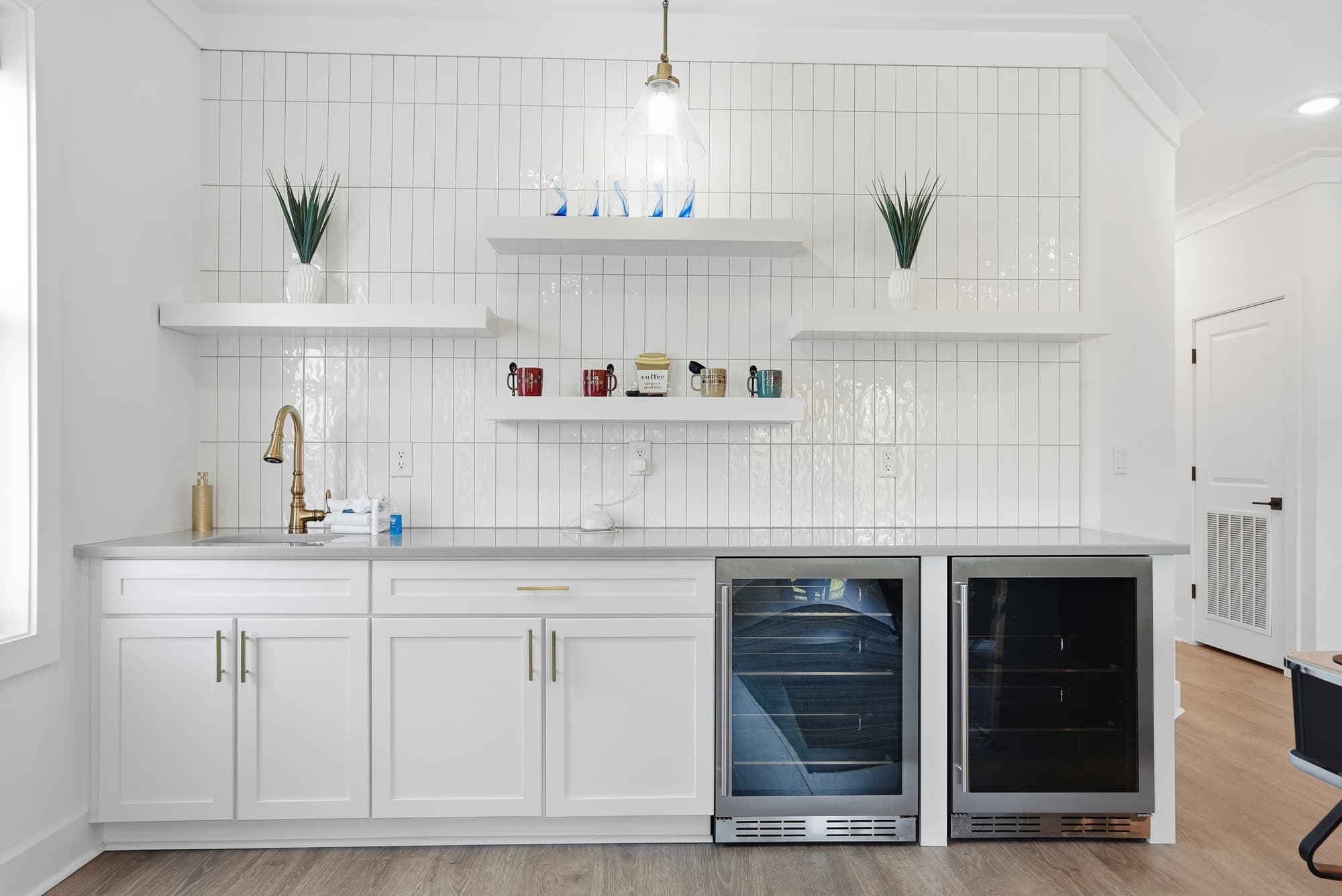 120 Dune Drive – Modern kitchen area with white cabinetry, stainless steel appliances, and decorative shelves.