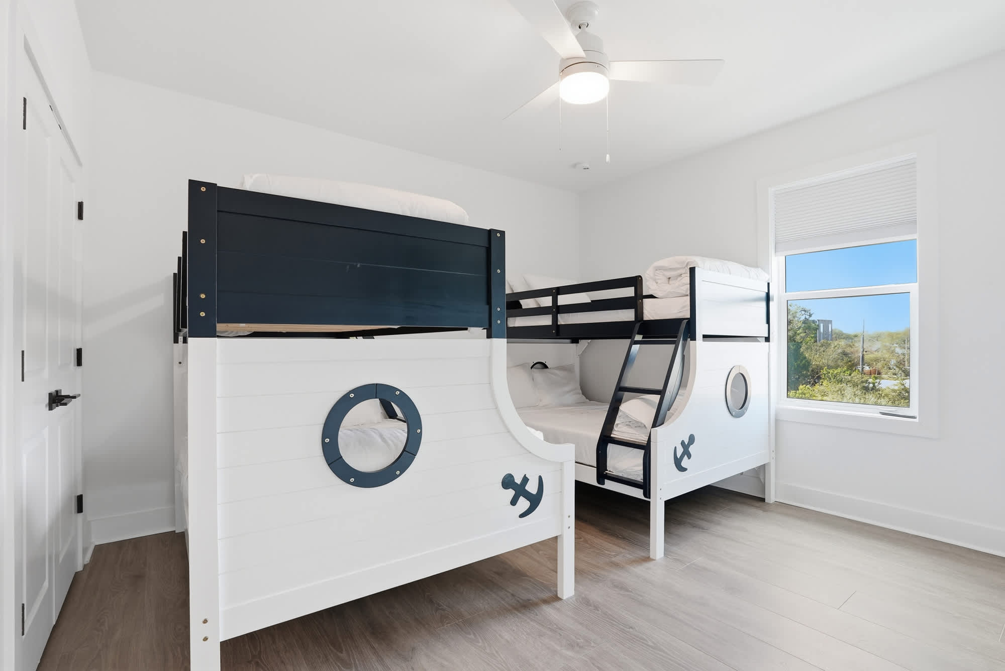 120 Dune Drive – Children's bedroom with nautical-themed bunk beds and a window view.