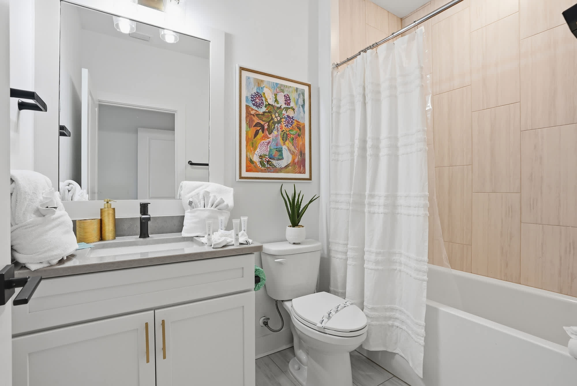 120 Dune Drive – Bathroom with a sink, toilet, bathtubs, shower curtain, and wall art.