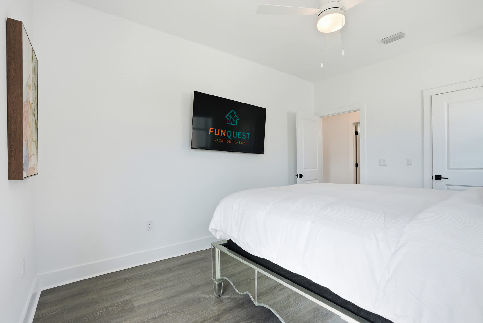 120 Dune Drive – Bright bedroom with a bed, flat-screen TV, and artwork on the wall.