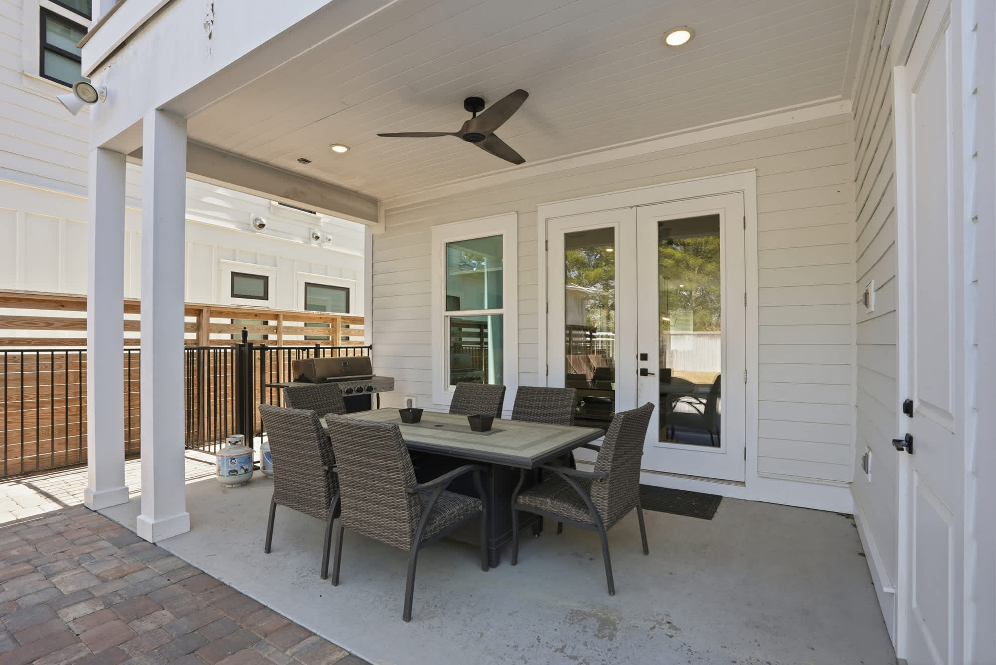 120 Dune Drive – Covered patio with dining table, six chairs, ceiling fan, and nearby barbecue grill.