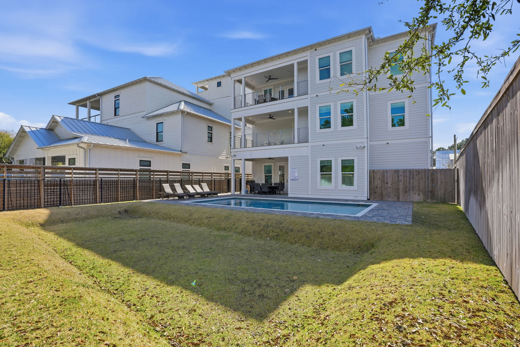 120 Dune Drive – Three-story vacation rental with pool, fenced yard, and multiple balconies.