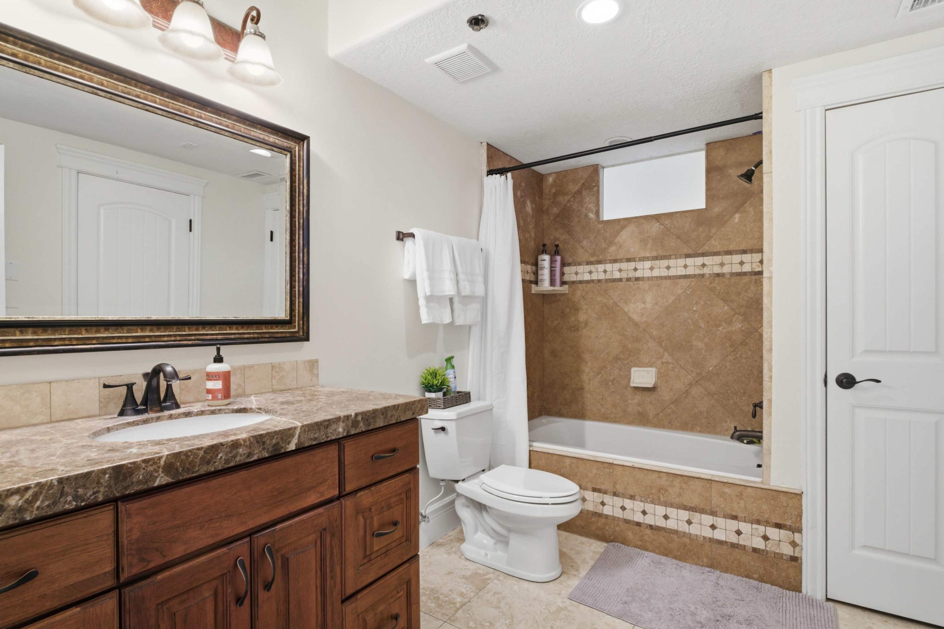 Elegant bathroom with upgraded tile and ample counter space