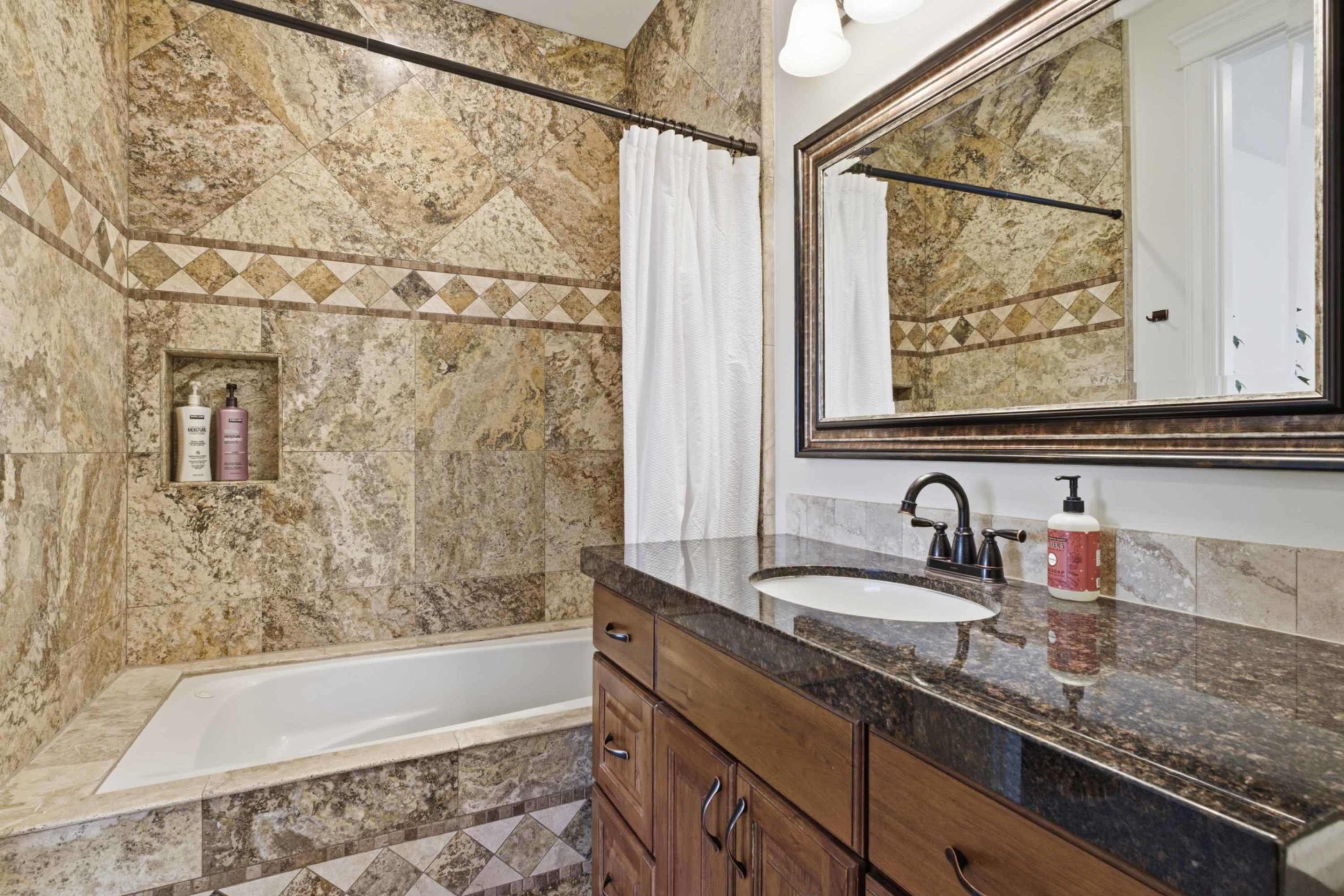Full bathroom featuring detailed stone tilework