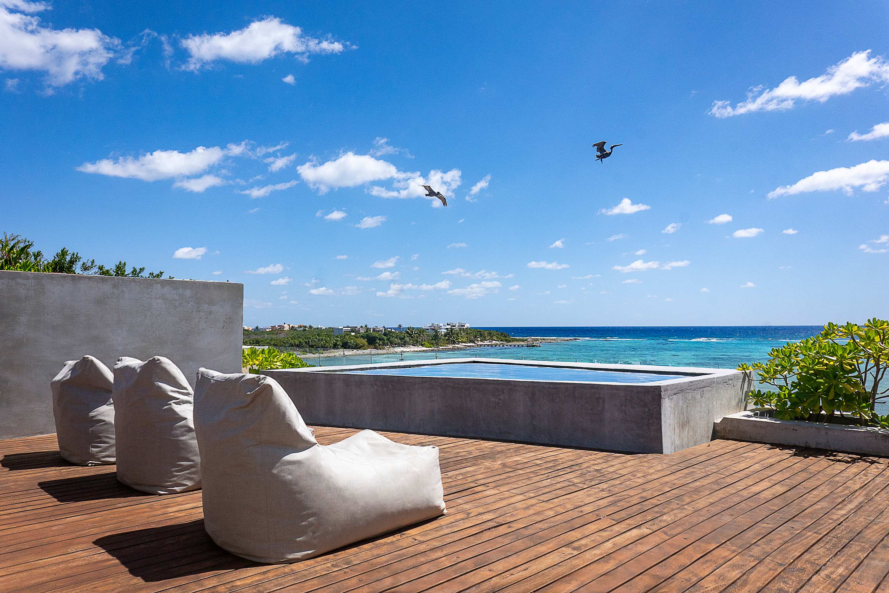 Private rooftop with sunbeds and poufs for sunbathing.