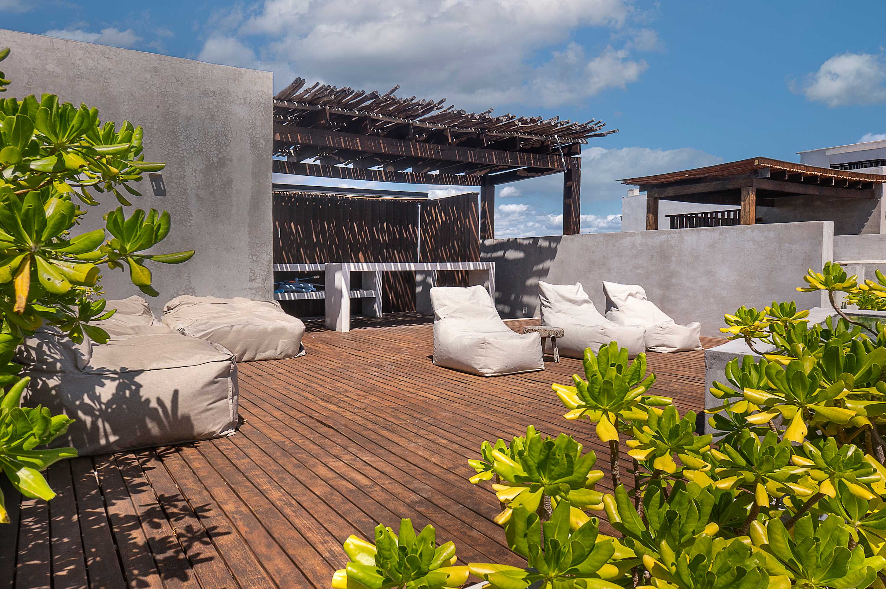 Private rooftop with sunbeds and poufs for sunbathing.