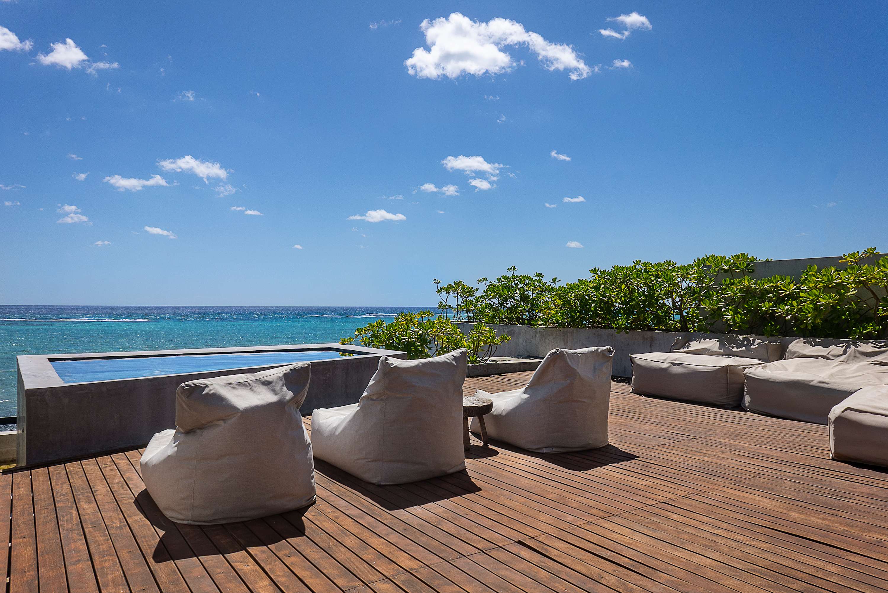 Private rooftop with sunbeds and poufs for sunbathing.