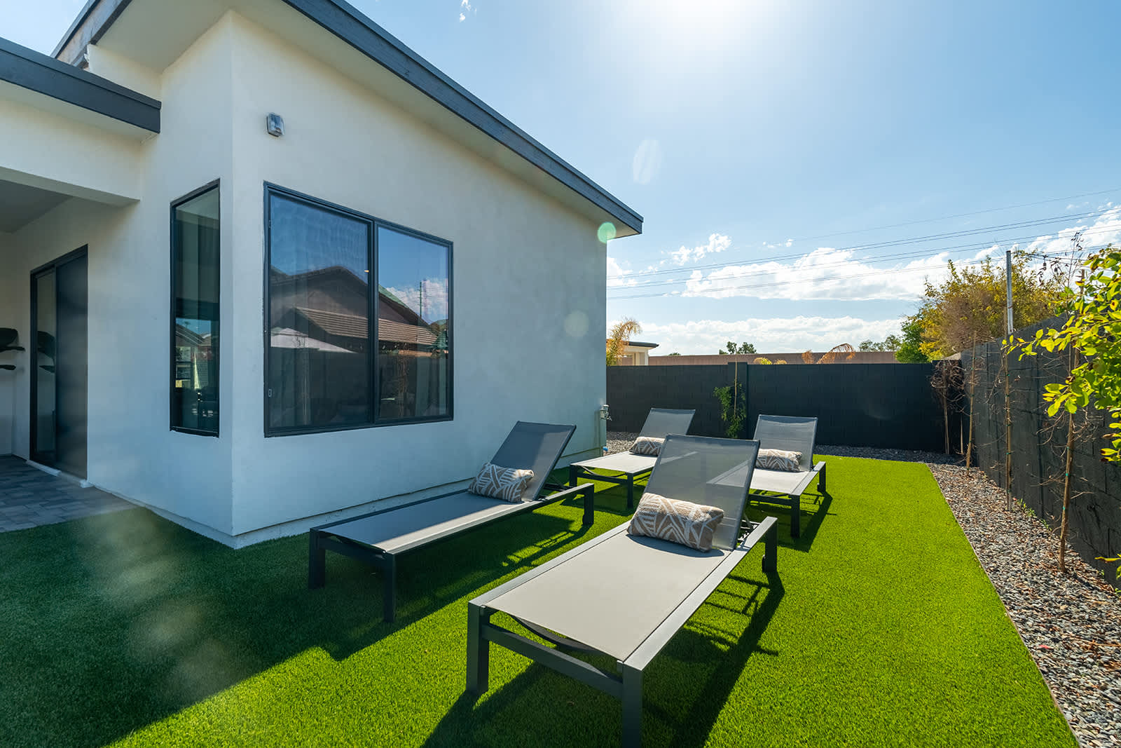 This stunning private yard features a sparkling pool, covered outdoor dining area, sun loungers, lawn space, built-in fire pit & BBQ Grill!