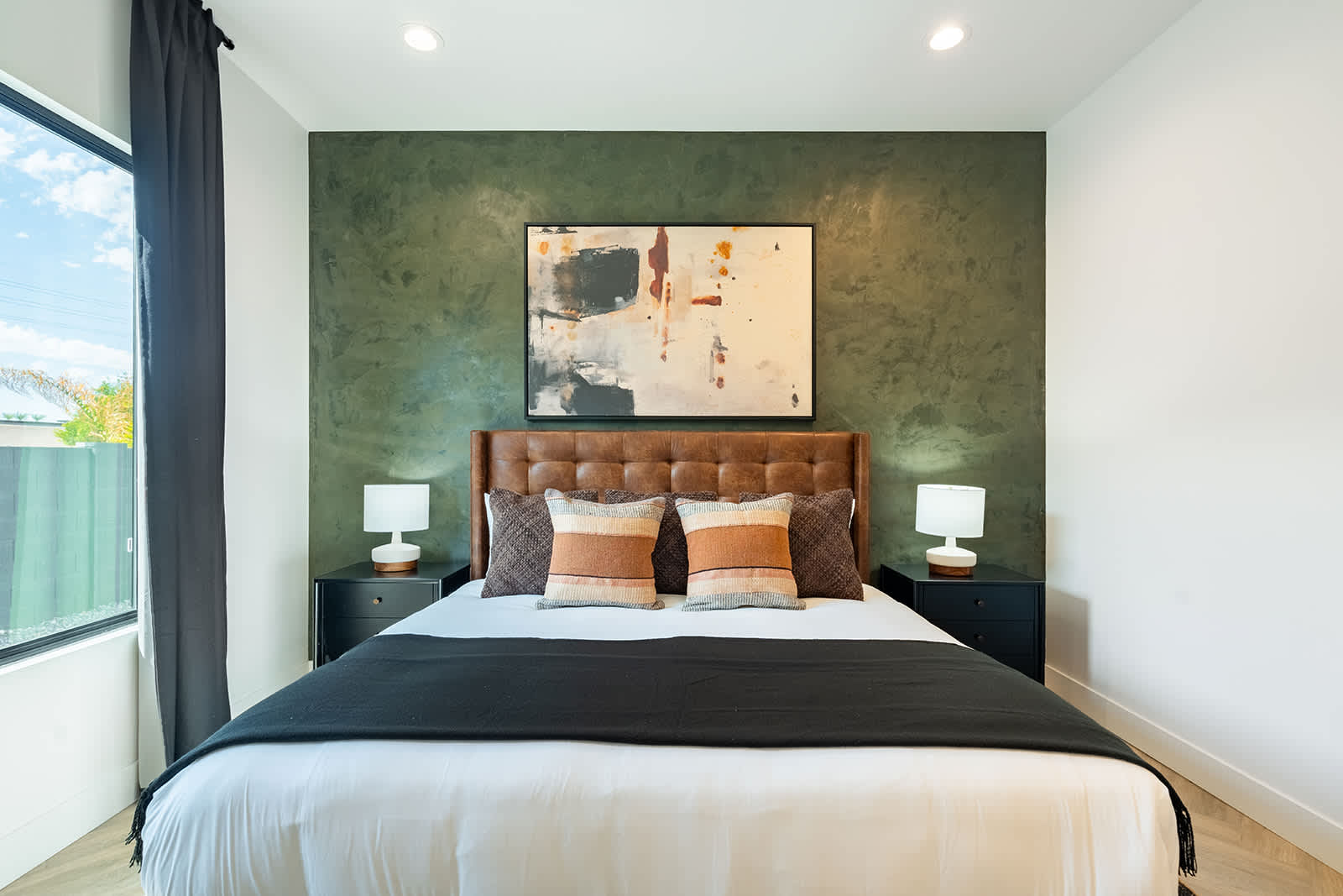 2nd bedroom with a King bed, smart TV, walk-in closet, custom accent wall, and an en-suite bathroom.