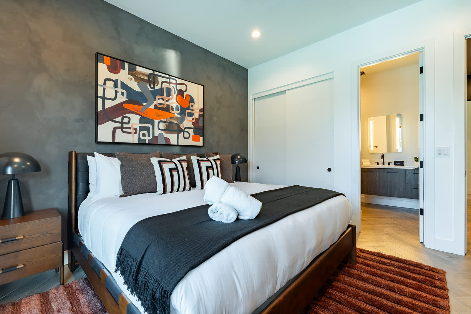 4th Bedroom offering a King bed, designer furnishings, smart TV, custom accent wall, closet space, and a jack and jill style en-suite bathroom.