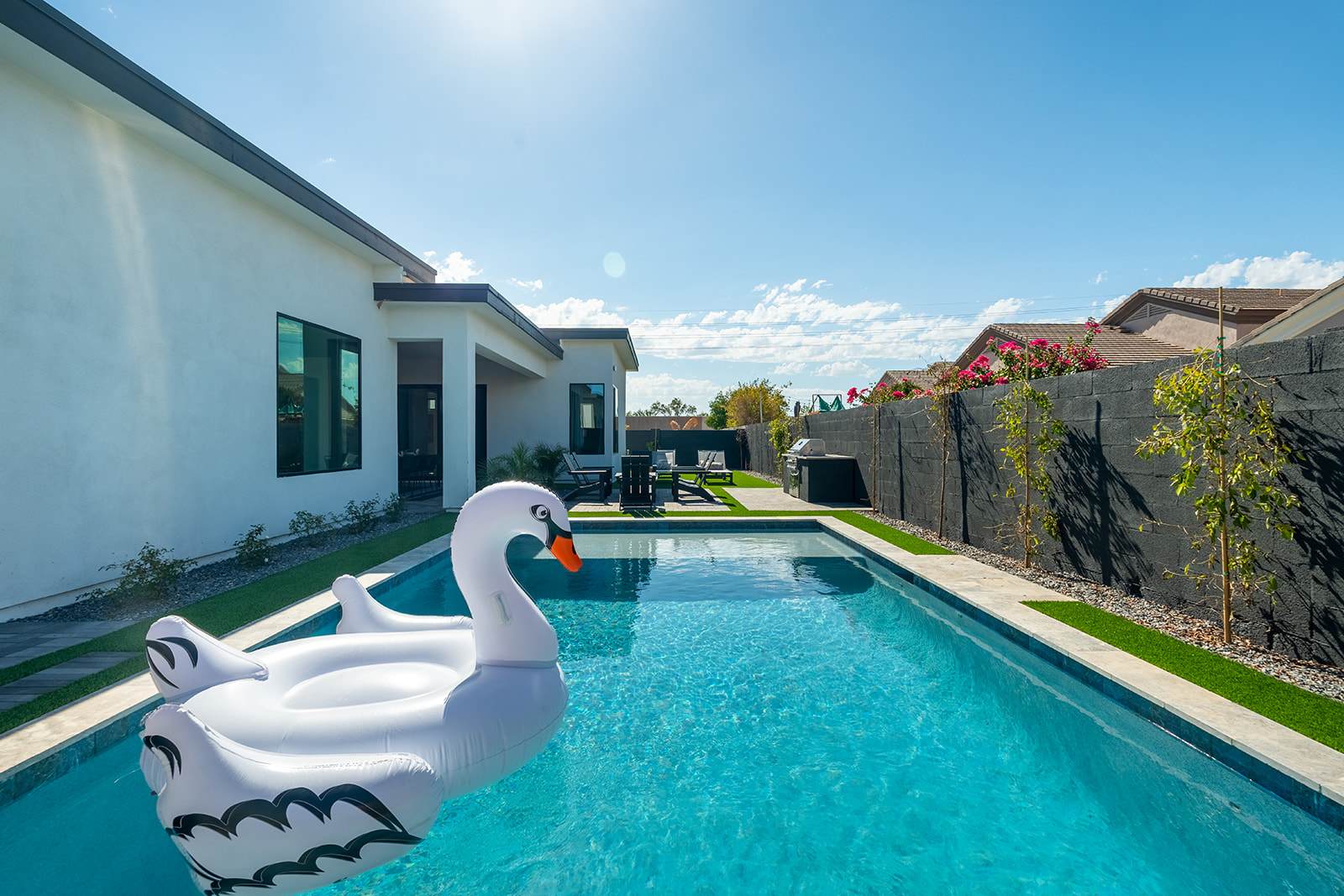 This stunning private yard features a sparkling pool, covered outdoor dining area, sun loungers, lawn space, built-in fire pit & BBQ Grill!