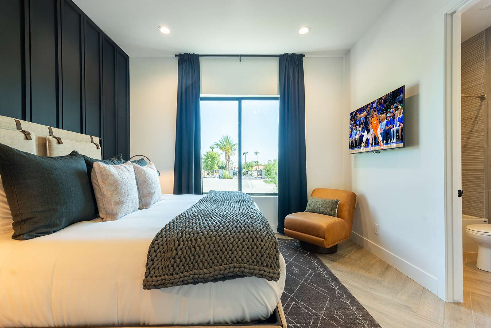 3rd bedroom featuring a King-sized bed, smart TV, designer furnishings, walk-in closet, en-suite bathroom, and custom accent wall.