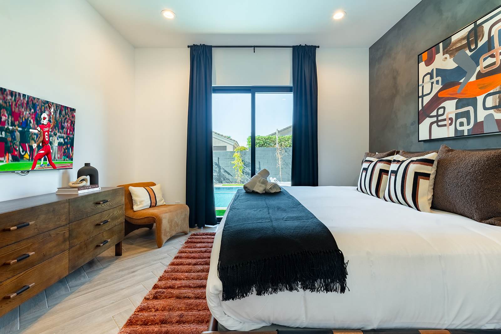 4th Bedroom offering a King bed, designer furnishings, smart TV, custom accent wall, closet space, and a jack and jill style en-suite bathroom.