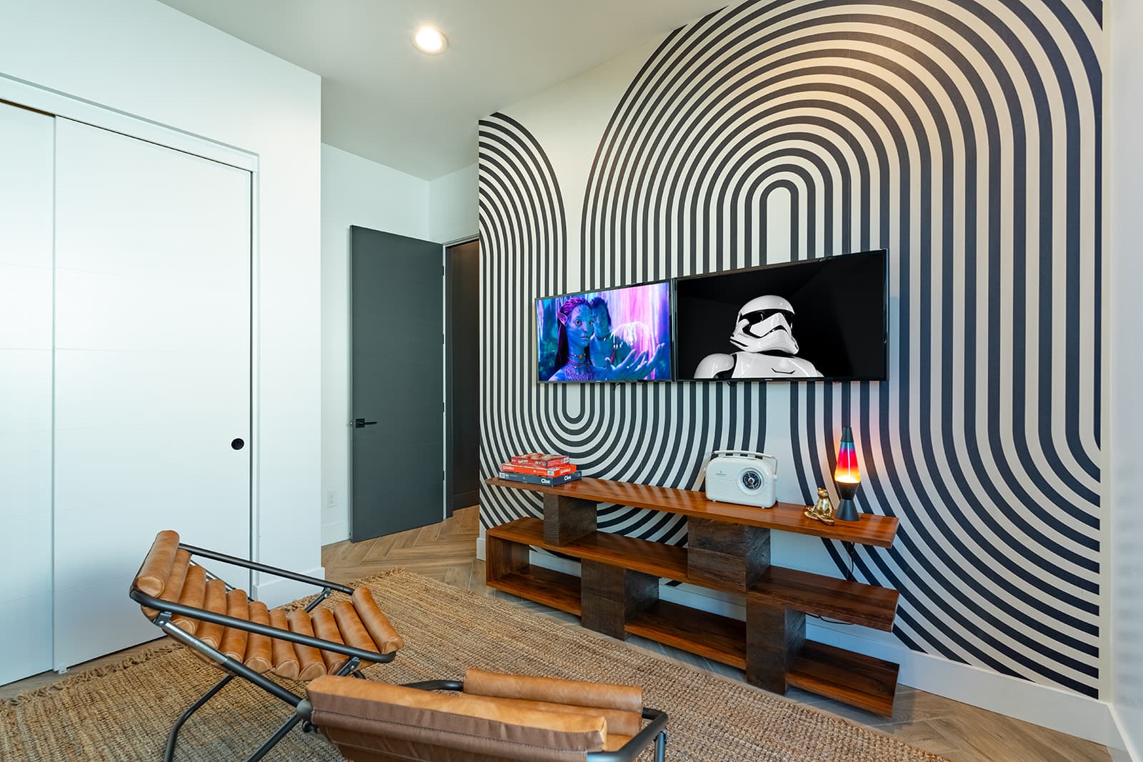 5th bedroom offering an accommodating layout featuring 2 full sized beds (bunk-style), closet space, smart TV, accent wall, and designer furnishings.