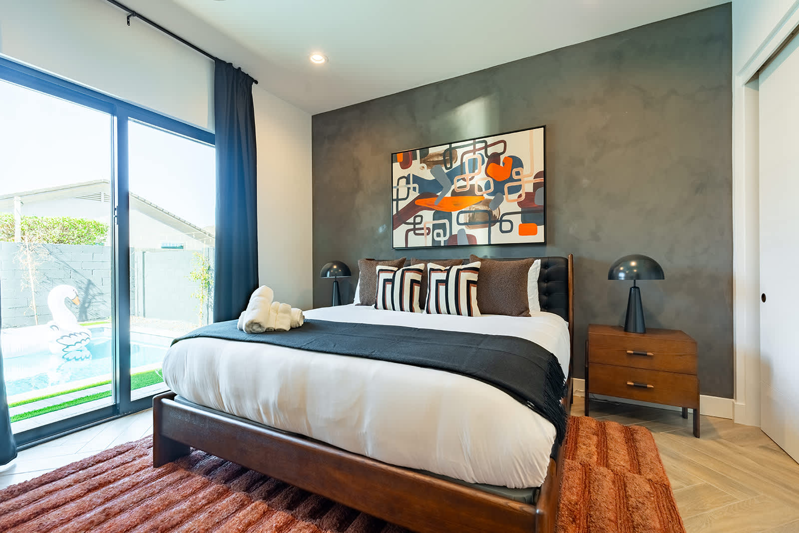 4th Bedroom offering a King bed, designer furnishings, smart TV, custom accent wall, closet space, and a jack and jill style en-suite bathroom.