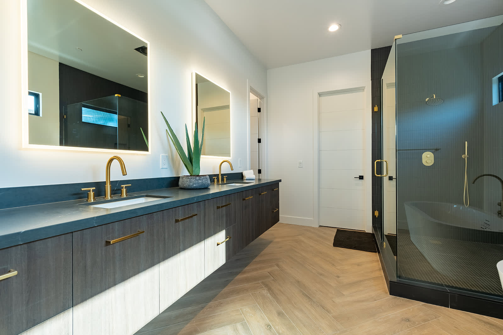 The Primary en-suite bathroom hosts a sleek walk-in shower, large soaking tub and a full wall dual vanity with LED lit mirrors.