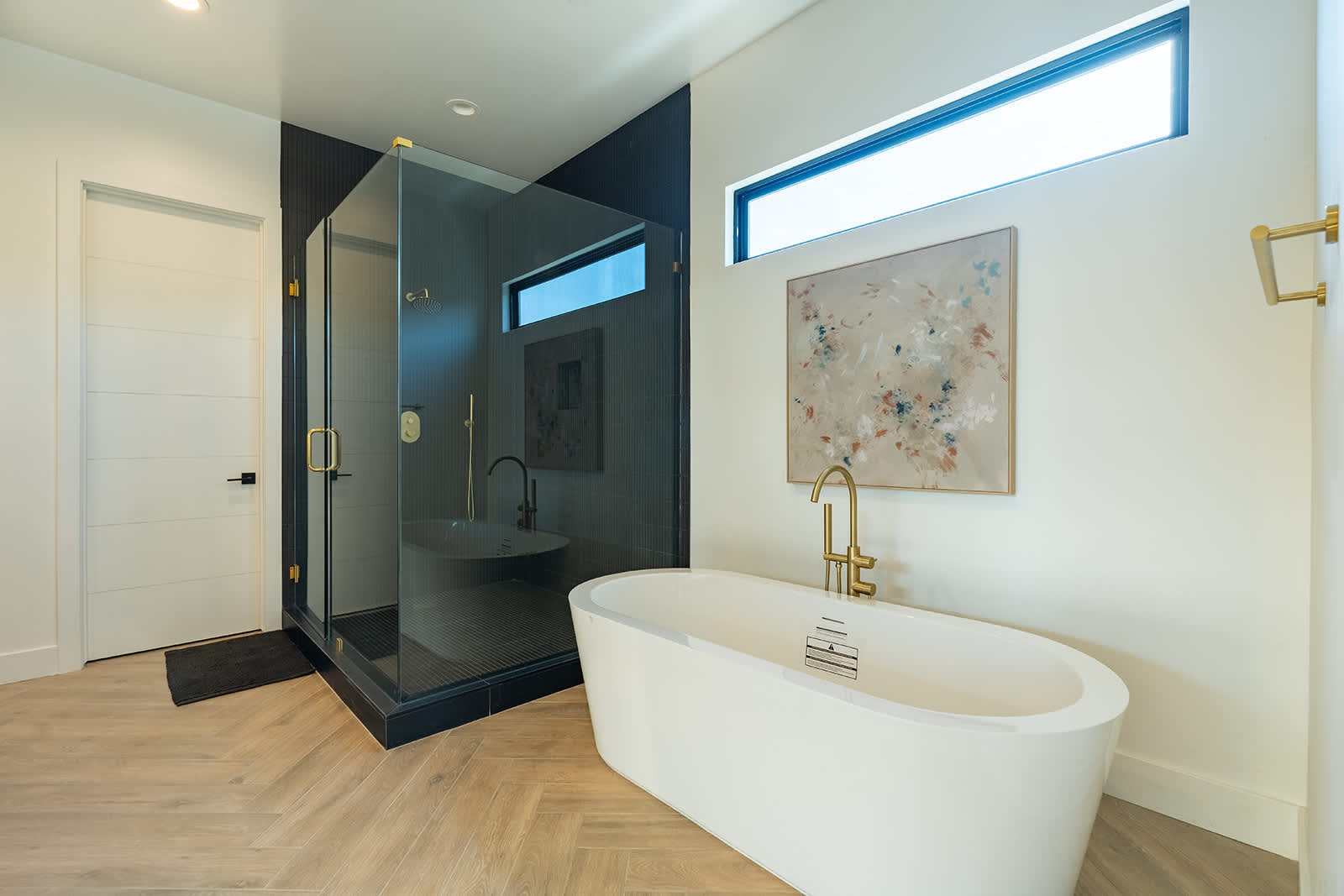 The Primary en-suite bathroom hosts a sleek walk-in shower, large soaking tub and a full wall dual vanity with LED lit mirrors.