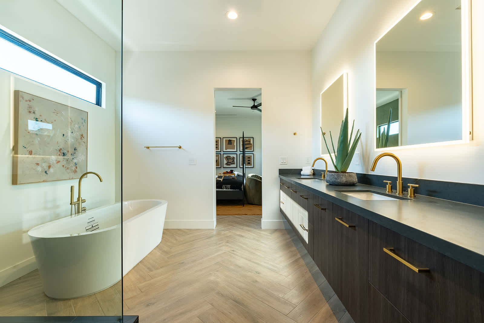 The Primary en-suite bathroom hosts a sleek walk-in shower, large soaking tub and a full wall dual vanity with LED lit mirrors.