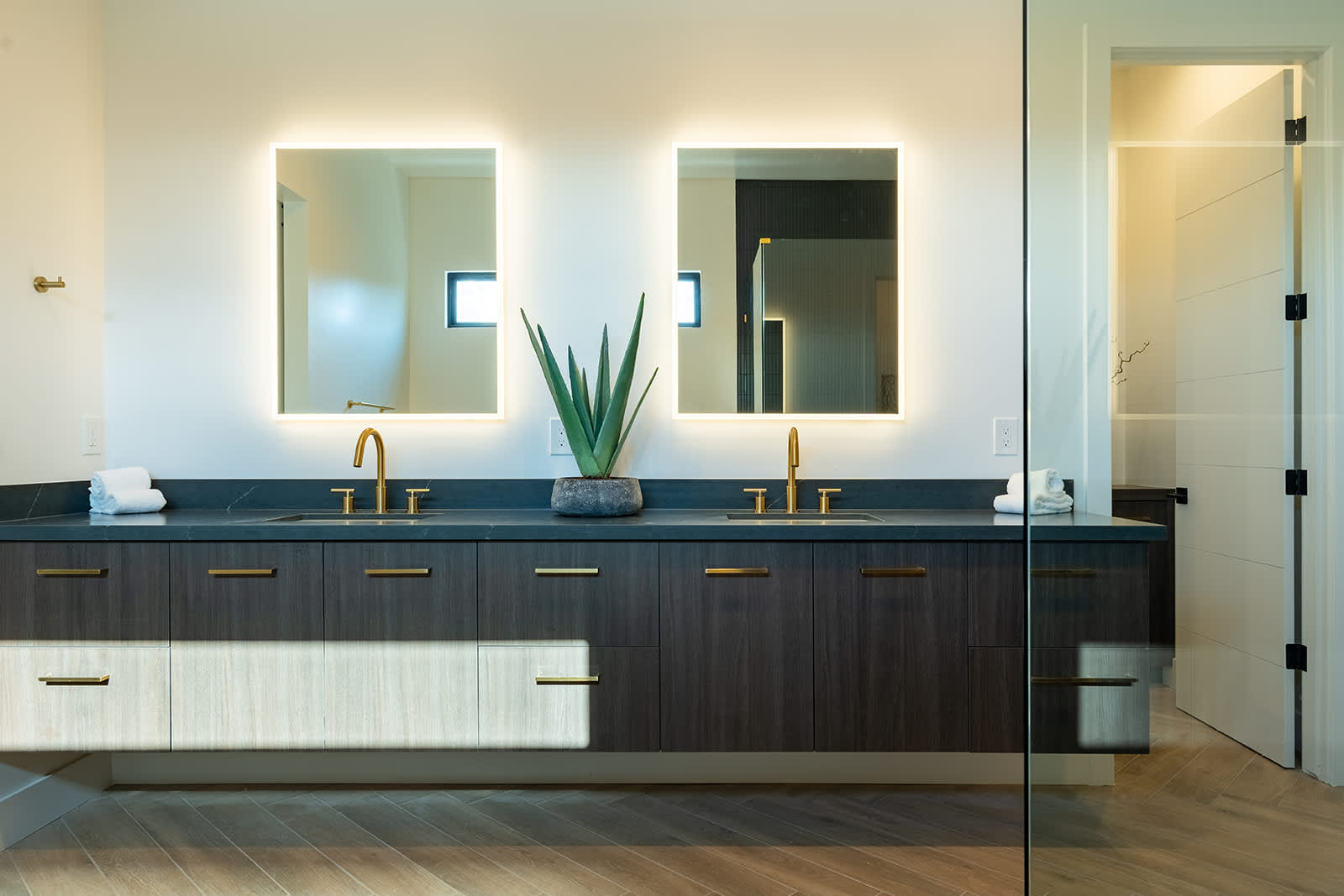 The Primary en-suite bathroom hosts a sleek walk-in shower, large soaking tub and a full wall dual vanity with LED lit mirrors.