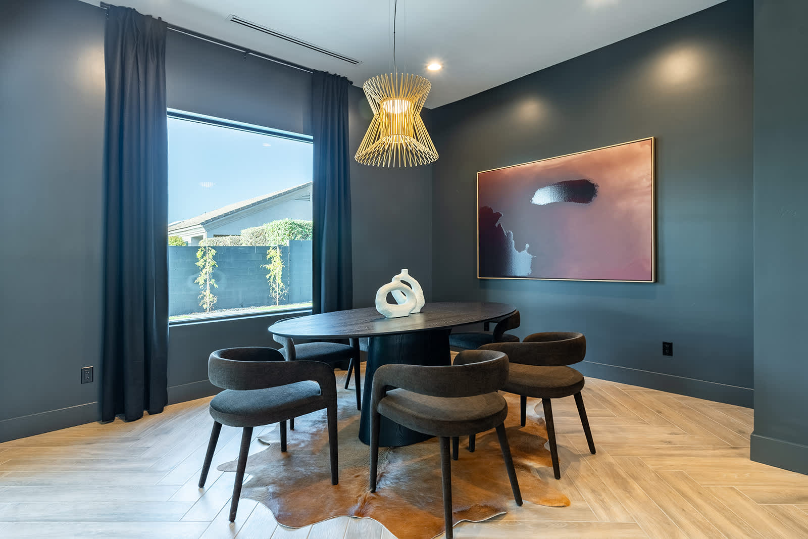 The modern dining area features a striking black wooden dinner table and seating for 6 in it's comfortable padded chairs.