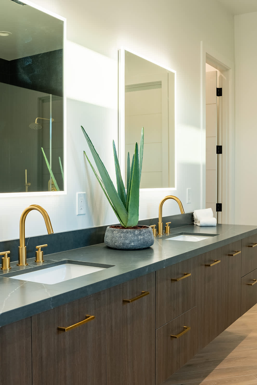 The Primary en-suite bathroom hosts a sleek walk-in shower, large soaking tub and a full wall dual vanity with LED lit mirrors.