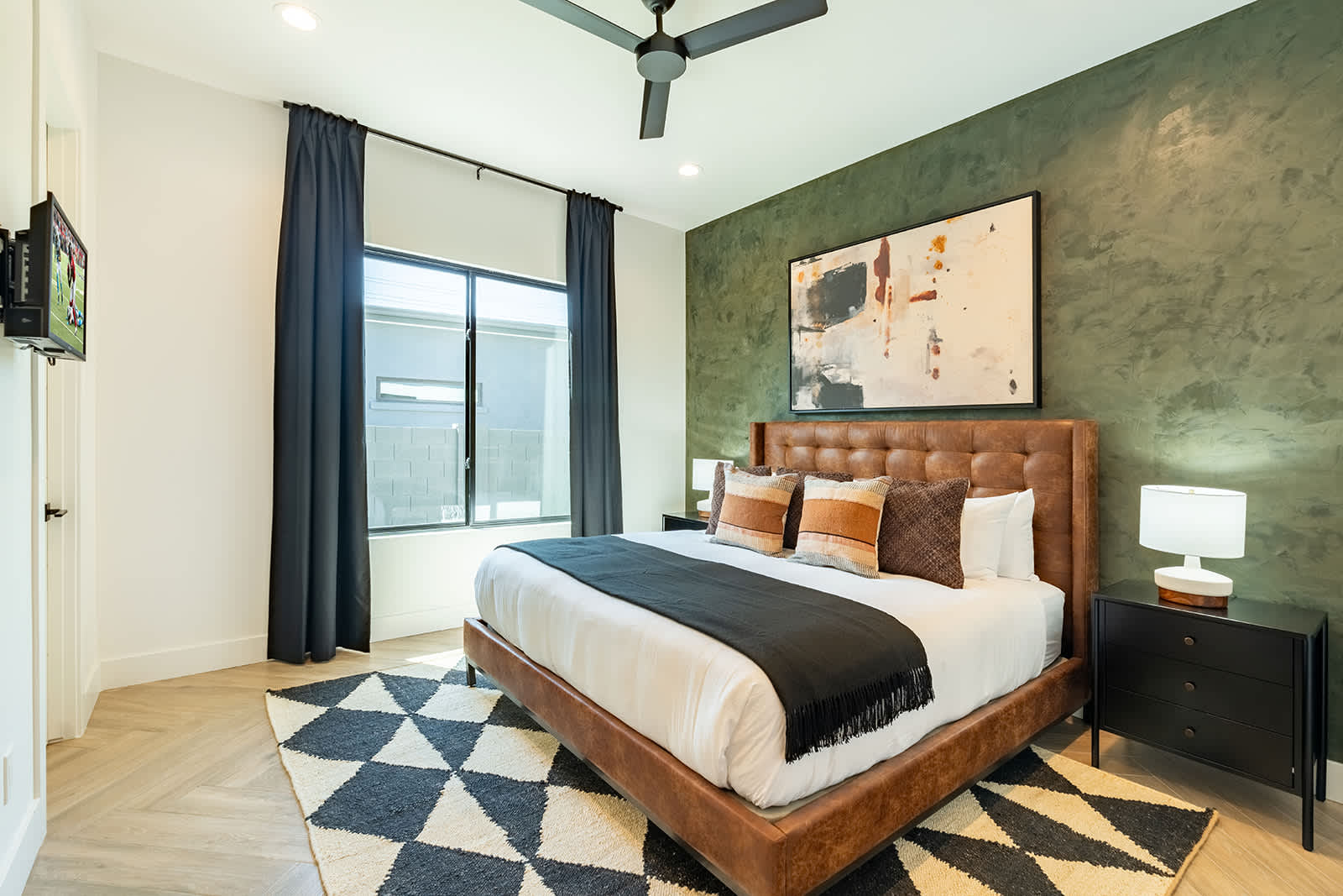 2nd bedroom with a King bed, smart TV, walk-in closet, custom accent wall, and an en-suite bathroom.