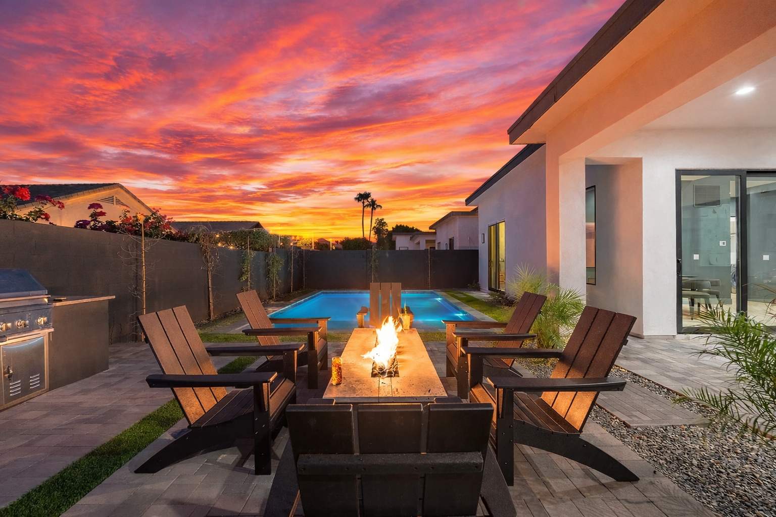 This stunning private yard features a sparkling pool, covered outdoor dining area, sun loungers, lawn space, built-in fire pit & BBQ Grill!