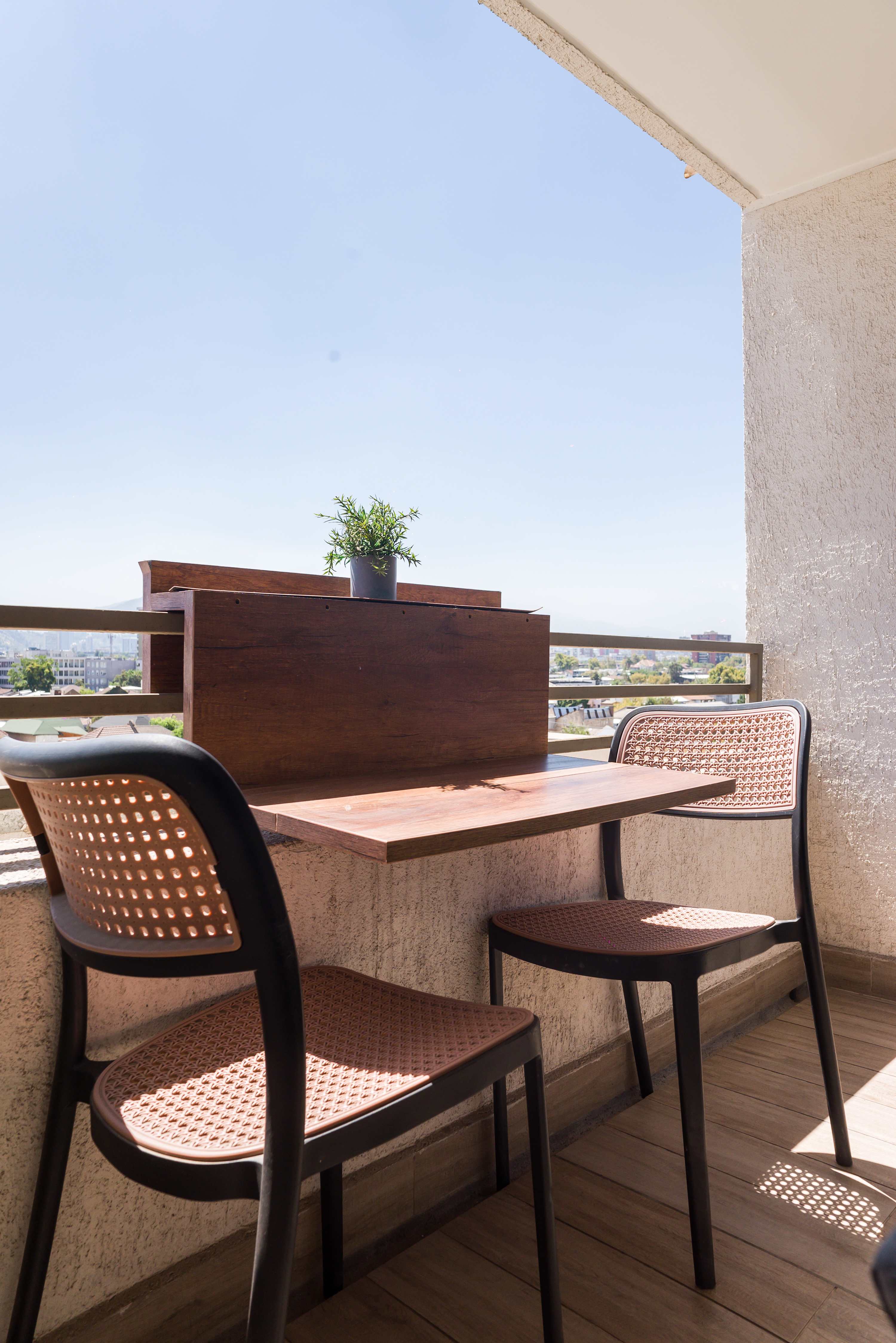Enjoy your morning coffee with a city view on this cozy balcony, perfect for relaxation.