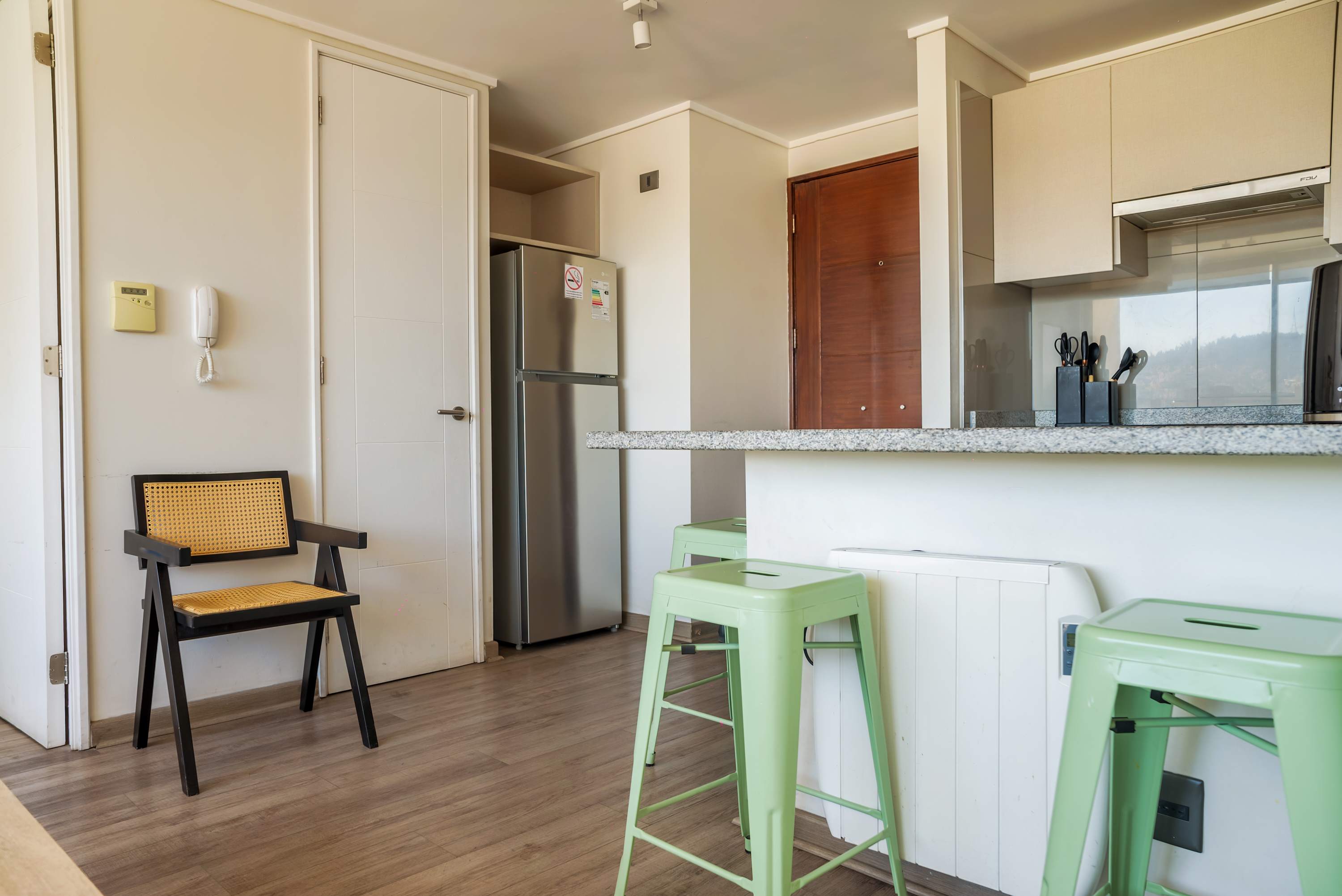 Modern kitchen with granite countertops and stylish seating, perfect for a cozy meal.
