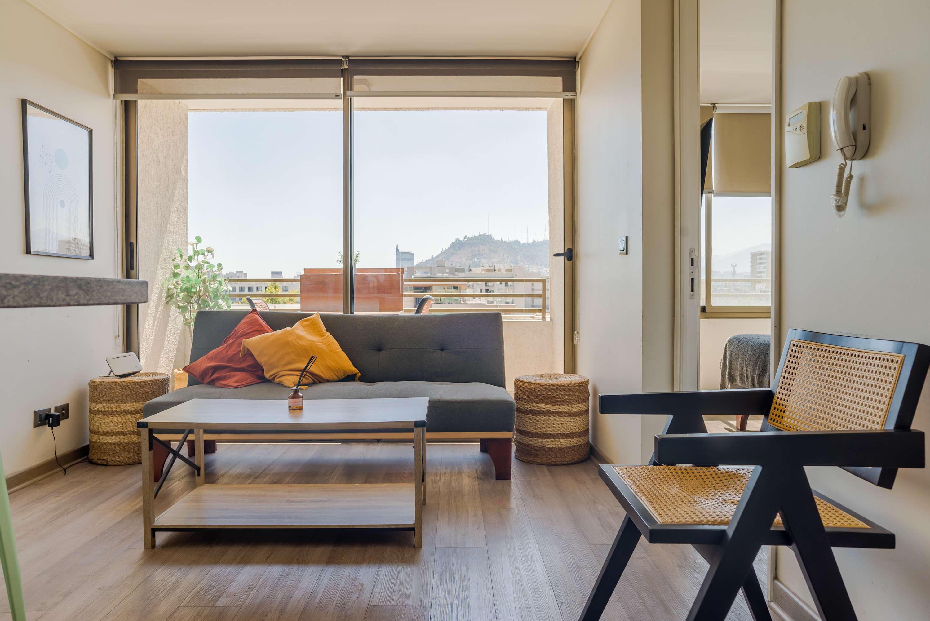 Relax in this bright living room with stunning views of the city and hills, perfect for unwinding after a day of exploring.