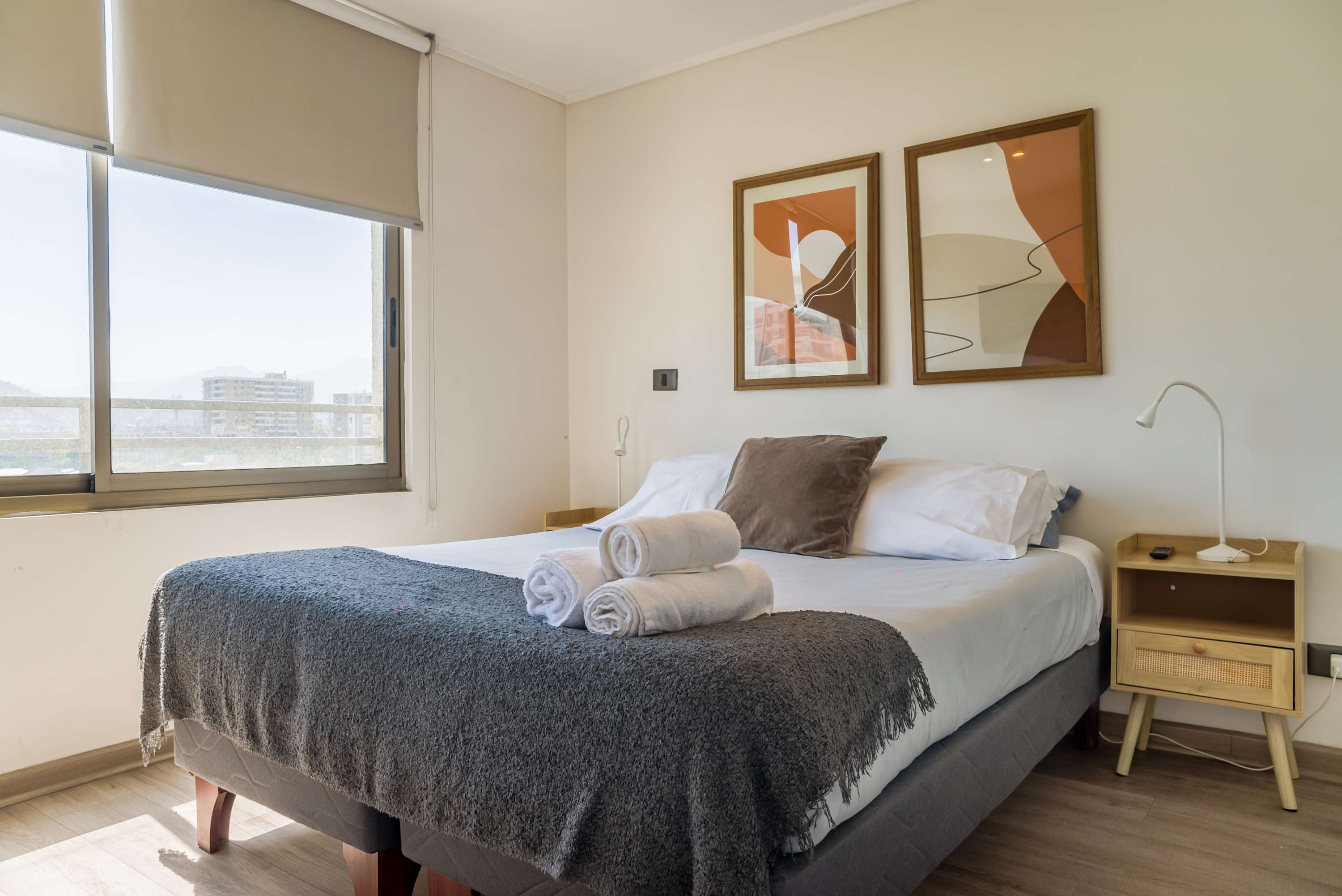 Cozy bedroom with city views, featuring modern decor and a comfortable bed for a restful stay.