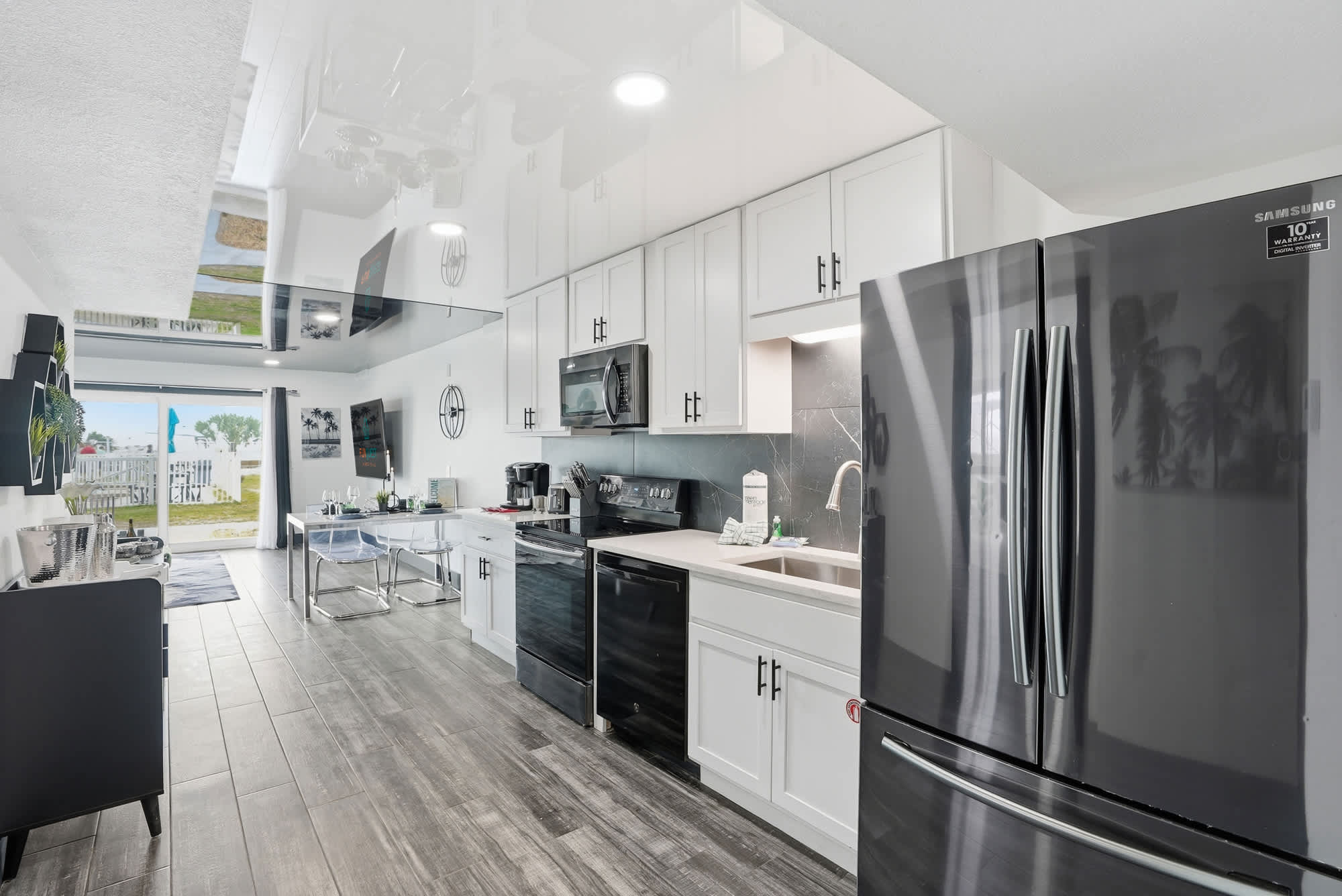 The Summit 132 – Modern kitchen with stainless steel appliances and outdoor view through sliding glass doors.
