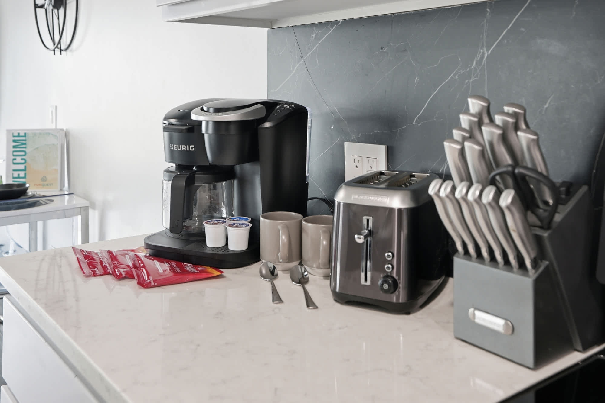The Summit 132 – Modern kitchen countertop featuring a Keurig coffee maker, toaster, knife set, and coffee accessories.